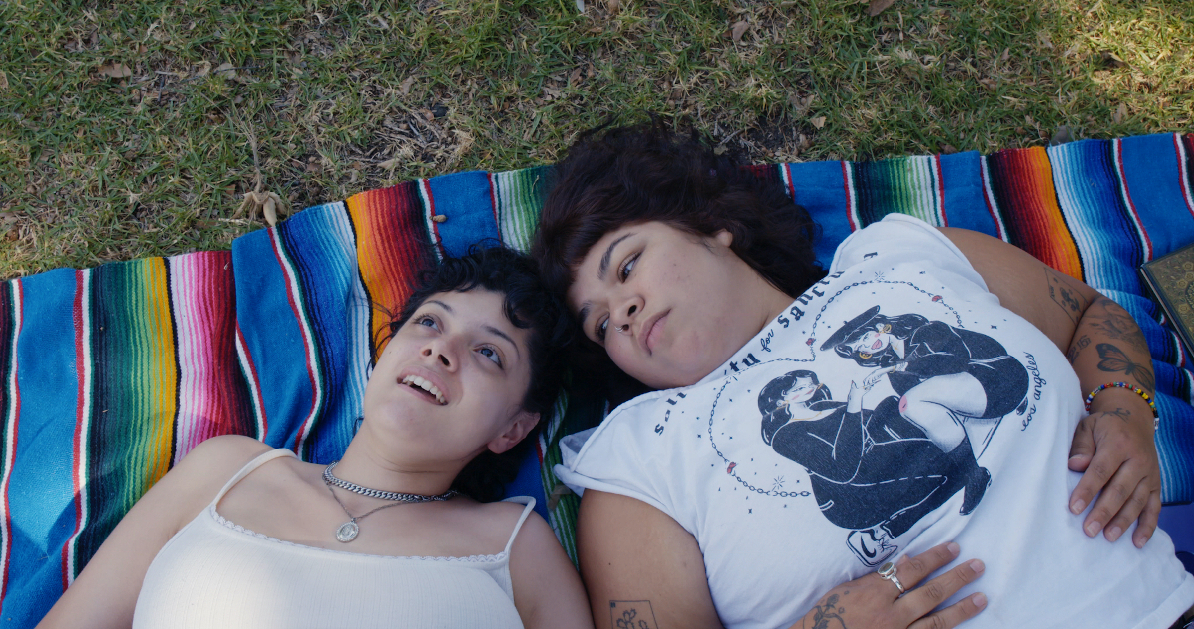 Doris Muñoz and Jacks Haupt lay on a multicolored blanket in the grass. (Courtesy of Disney)