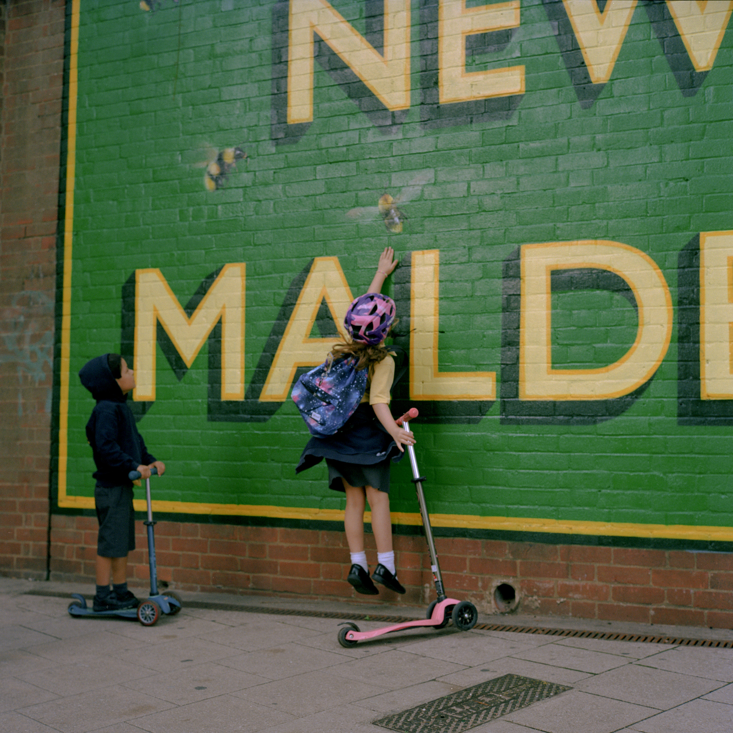 Two children play in front of a mural outside New Malden train station. (Michael Vince Kim for TIME)