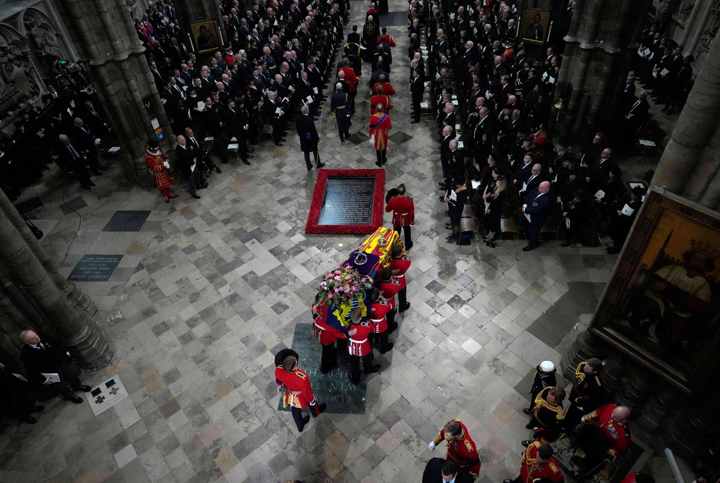 The coffin of Queen Elizabeth II with the imperial state crown resting on top is carried by the bearer party into Westminster Abbey during the State Funeral of Queen Elizabeth II. (Frank Augstein—Pool/AFP/Getty Images)