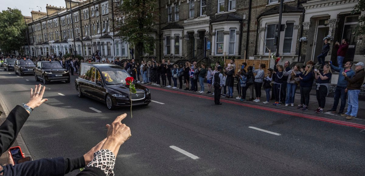 A person throws a flower towards Britain's Queen Elizabeth's coffin as it is transported on the day of her state funeral and burial.