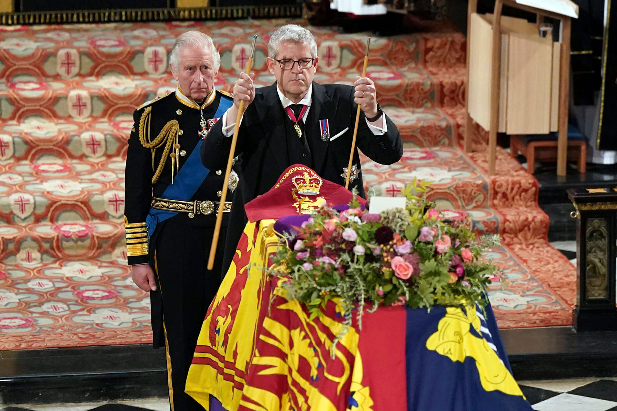 King Charles II, left, watches as The Lord Chamberlain Baron Parker breaks his Wand of Office, marking the end of his service to the sovereign, during a committal service for Britain's Queen Elizabeth II at St George's Chapel, Windsor Castle, in Windsor, England, Monday, Sept. 19, 2022.