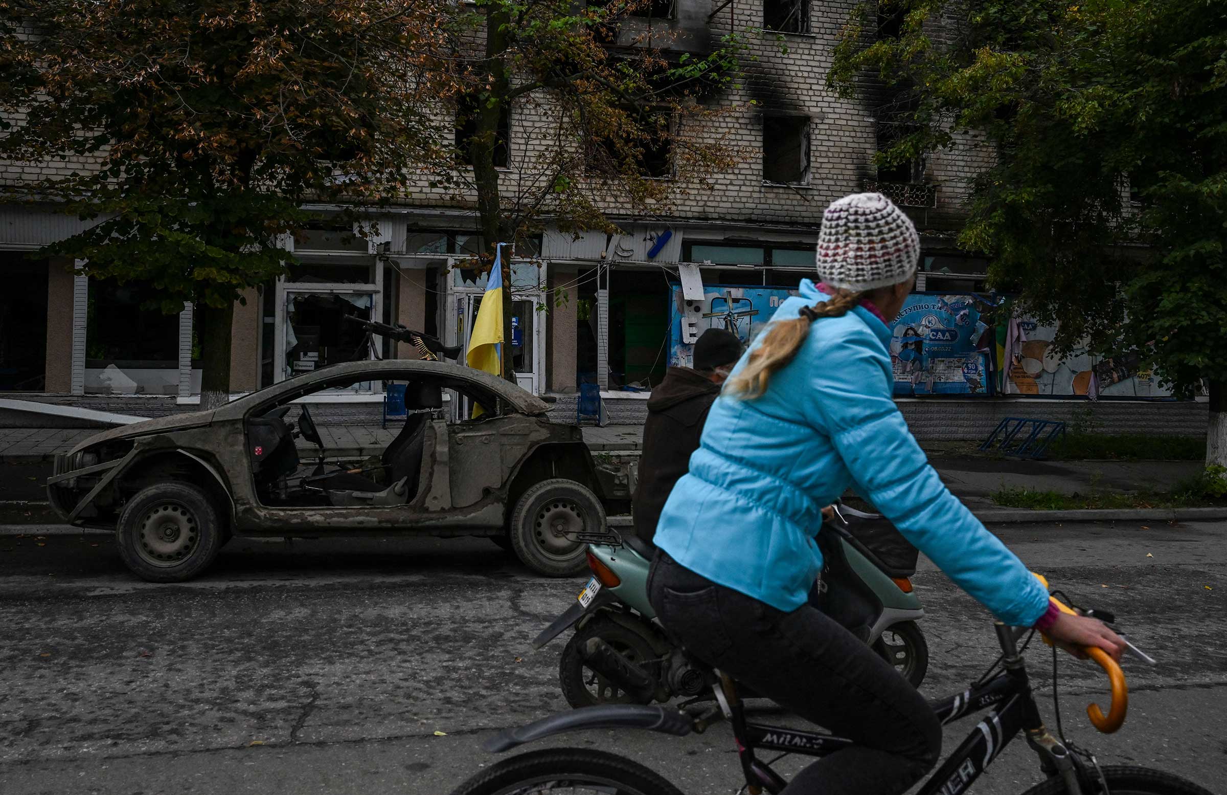 A woman rides a bicycle on a street in Izyum, Sept. 14. (Juan Barreto—AFP/Getty Images)