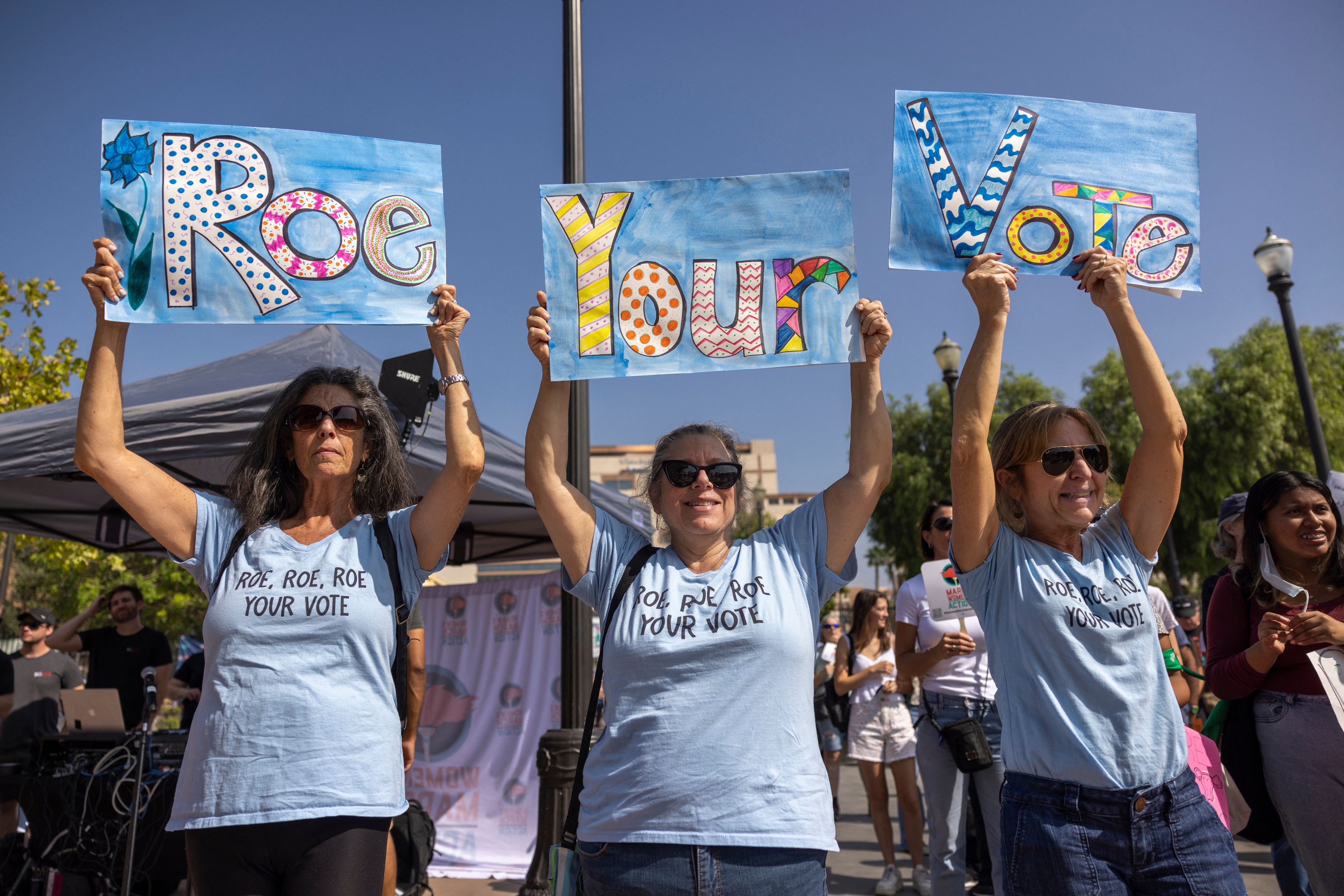 People hold placards during the Women's March Action Rally for Reproductive Rights at Mariachi Plaza in Los Angeles, on Oct. 8, 2022. (DAVID MCNEW—AFP/Getty Images)