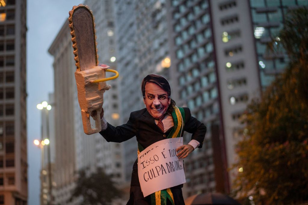 An activist wearing a mask depicting Brazilian President Jair Bolsonaro takes part in a demonstration against Bolsonaro's environmental policies and the destruction of the Amazon rainforest in Rio de Janeiro, Brazil, on September 05, 2019. (Mauro Pimentel—AFP/Getty Images)