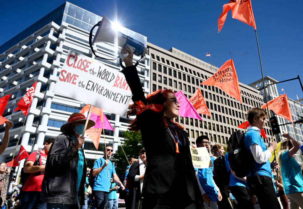 Climate activists protest outside the World Bank headquarters against fossil fuel projects during the IMF and World Bank annual meetings in Washington, DC on October 14, 2022. (OLIVIER DOULIERY-AFP)