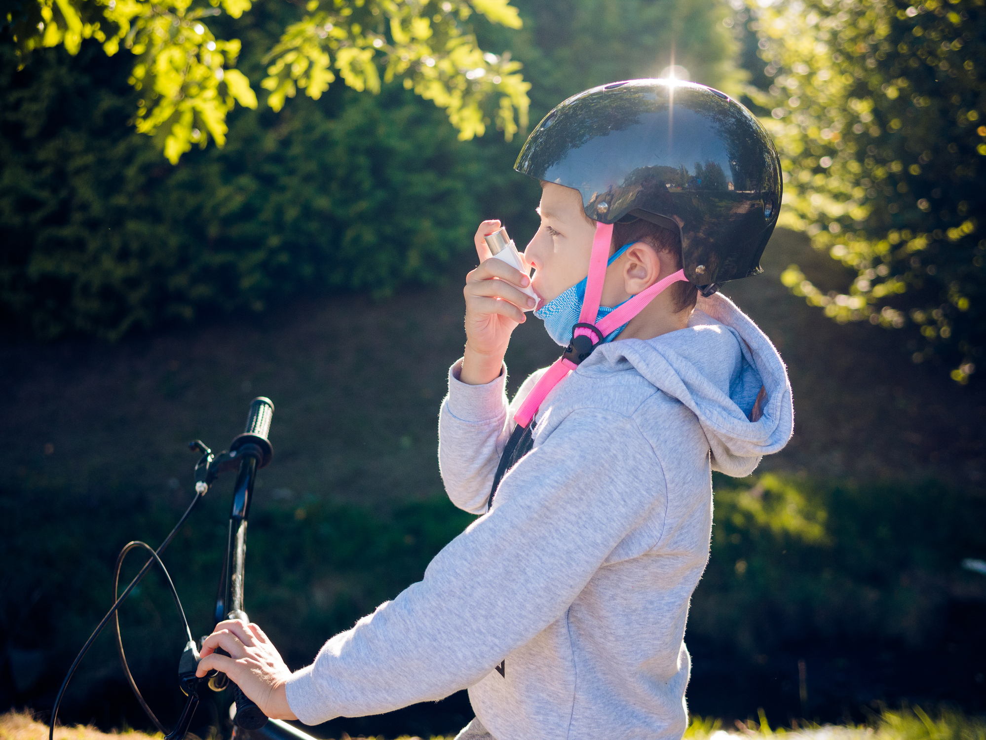 Young boy using an inhalator outdoors