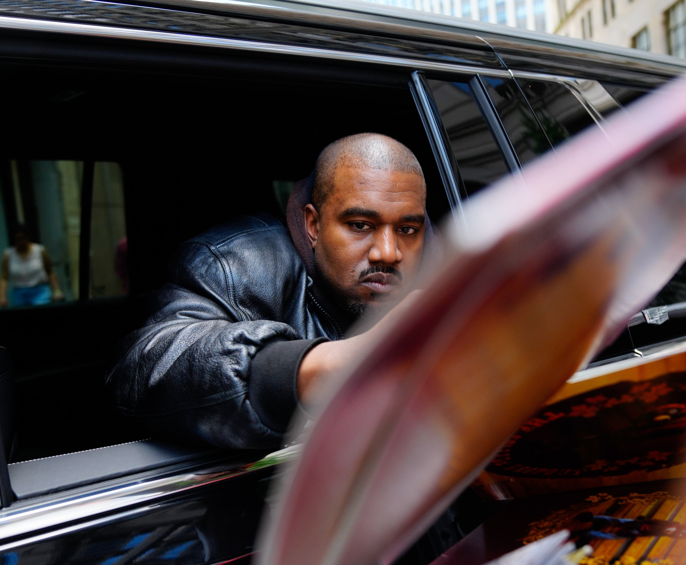 Kanye West signing albums out of a car window