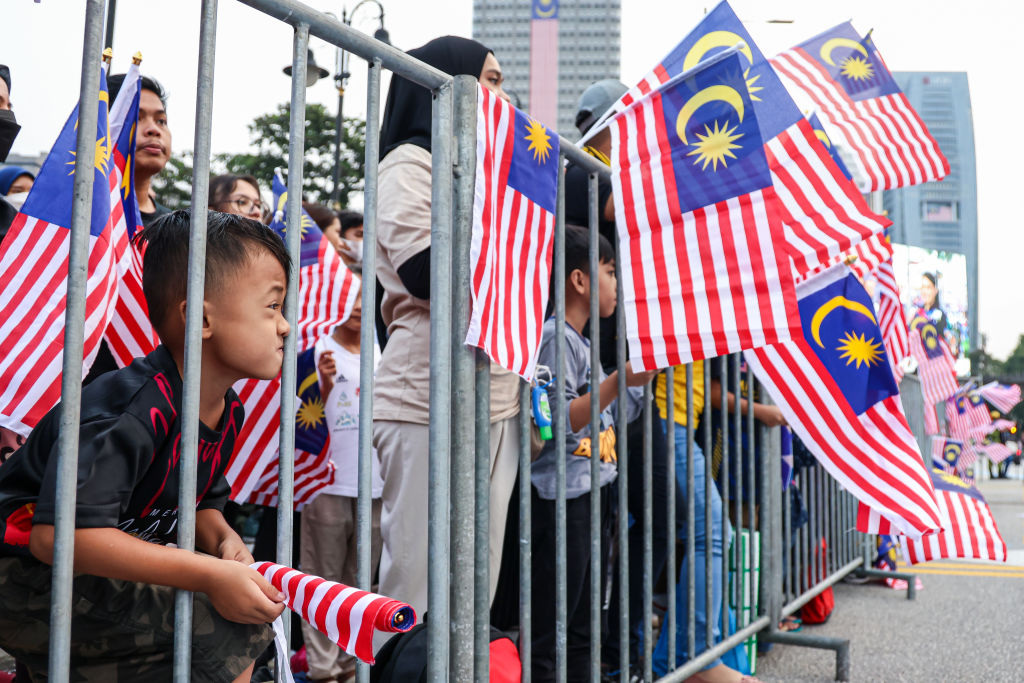 Jóvenes malayos celebran el 65.° Día de la Independencia del país, en Kuala Lumpur el 31 de agosto de 2022. (Annice Lyn—Getty Images)