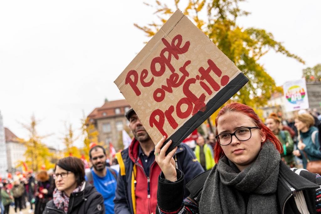 Protester hold a sign that reads "People over profits" as people march to demand a continued shift to renewable energy sources and reduction in fossil fuel dependence despite the current energy crisis on October 22, 2022 in Berlin, Germany. (Maja Hitij-Getty Images)