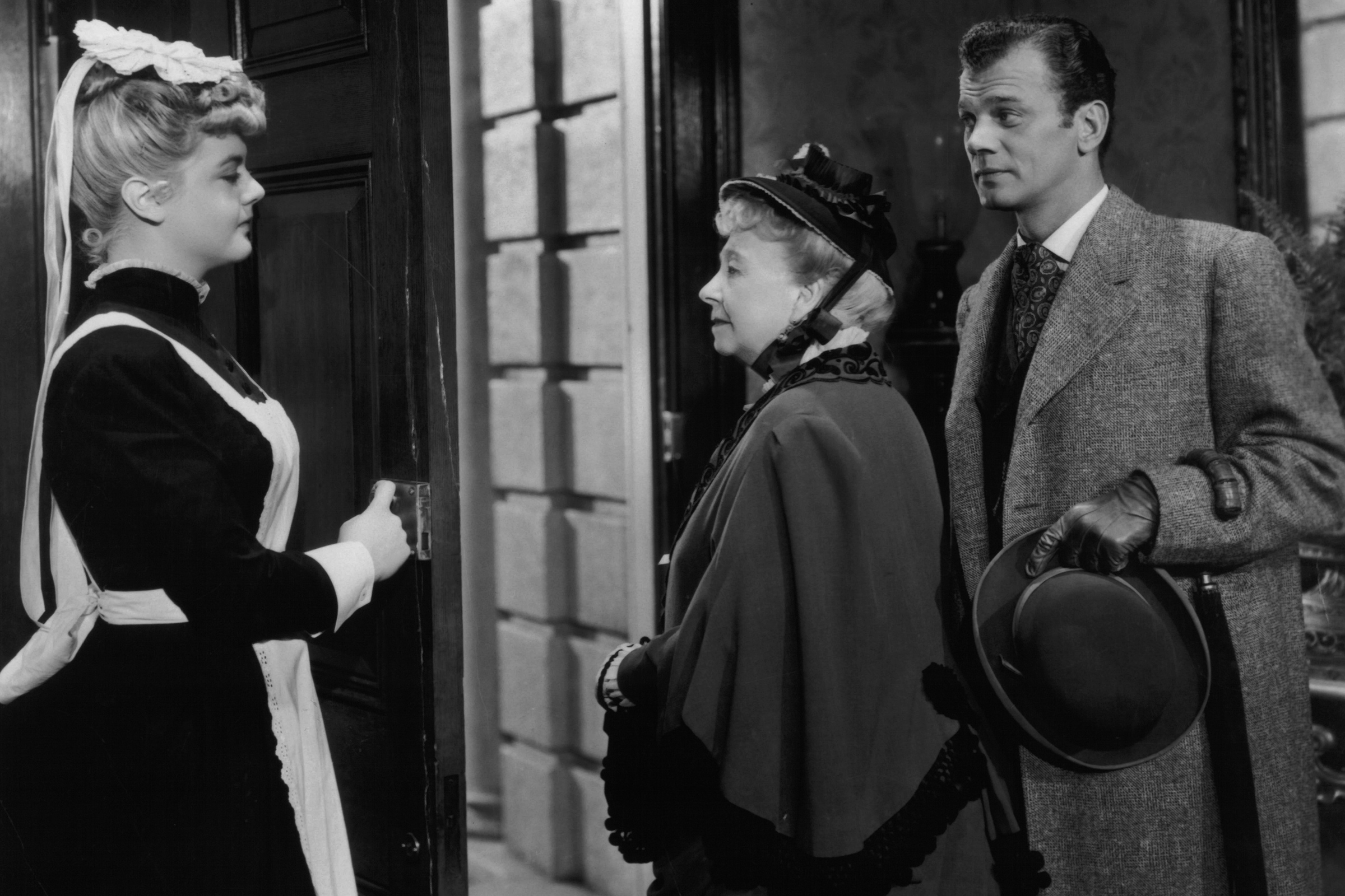 Angela Lansbury opens the door for Dame May Whitty and Joseph Cotten in a scene from the film 'Gaslight', in 1944.