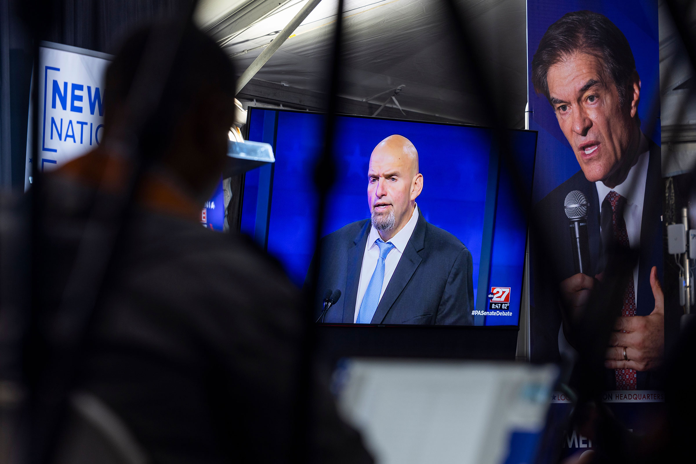 Members of the media watch John Fetterman face off against Mehmet Oz on a TV monitor during the candidates' only debate in Harrisburg, Pa., on Oct. 25. (Jim Lo Scalzo—EPA-EFE/Shutterstock)