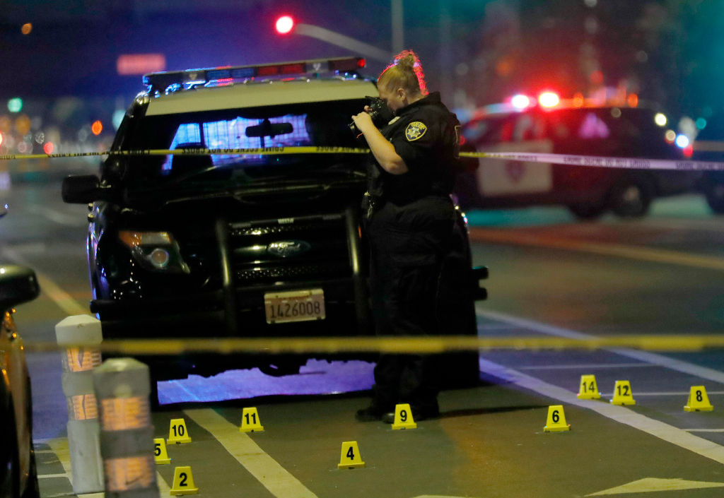 An Oakland police crime scene technician takes photos as they investigate a triple shooting in the 3100 block of Telegraph Avenue in Oakland, Calif., on Monday, Sept. 19, 2022. (Jane Tyska—Getty)