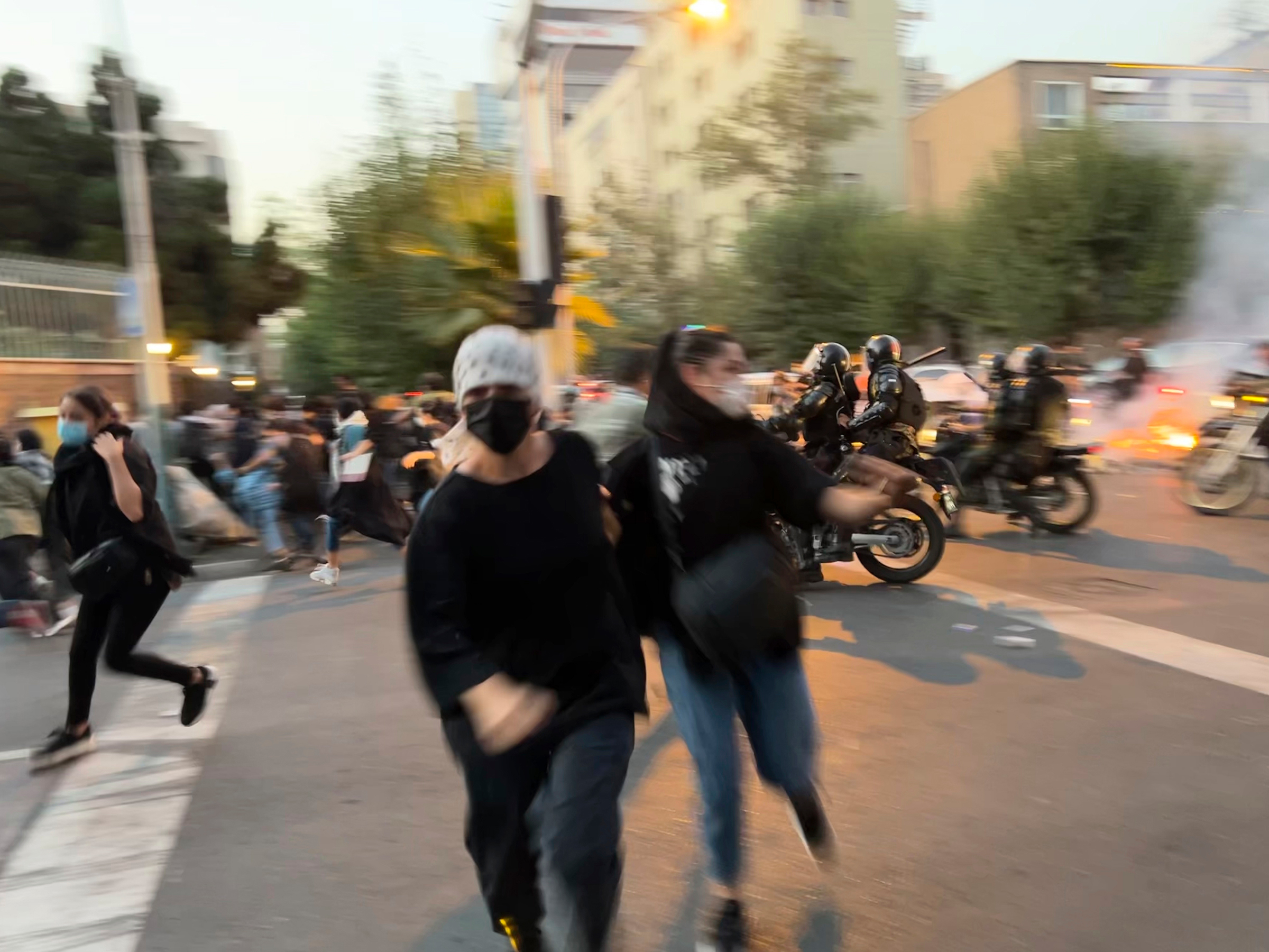 Women run away from anti-riot police during a protest of the death of a young woman, Mahsa Amini, who had been detained for violating the country's conservative dress code, in downtown Tehran on Sept. 19. (AP)