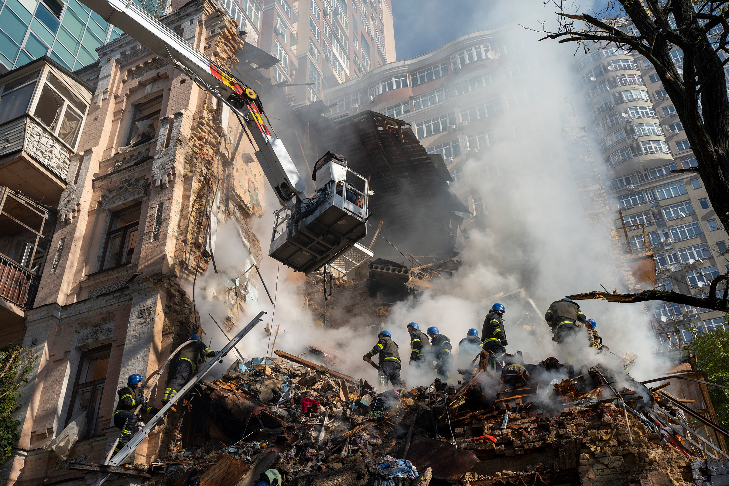 Firefighters work after a drone attack on buildings in Kyiv, Ukraine on Oct. 17. Waves of explosive-laden suicide drones struck Ukraine's capital as families were preparing to start their week early Monday, the blasts echoing across Kyiv, setting buildings ablaze and sending people scurrying to shelters. (Roman Hrytsyna—AP)