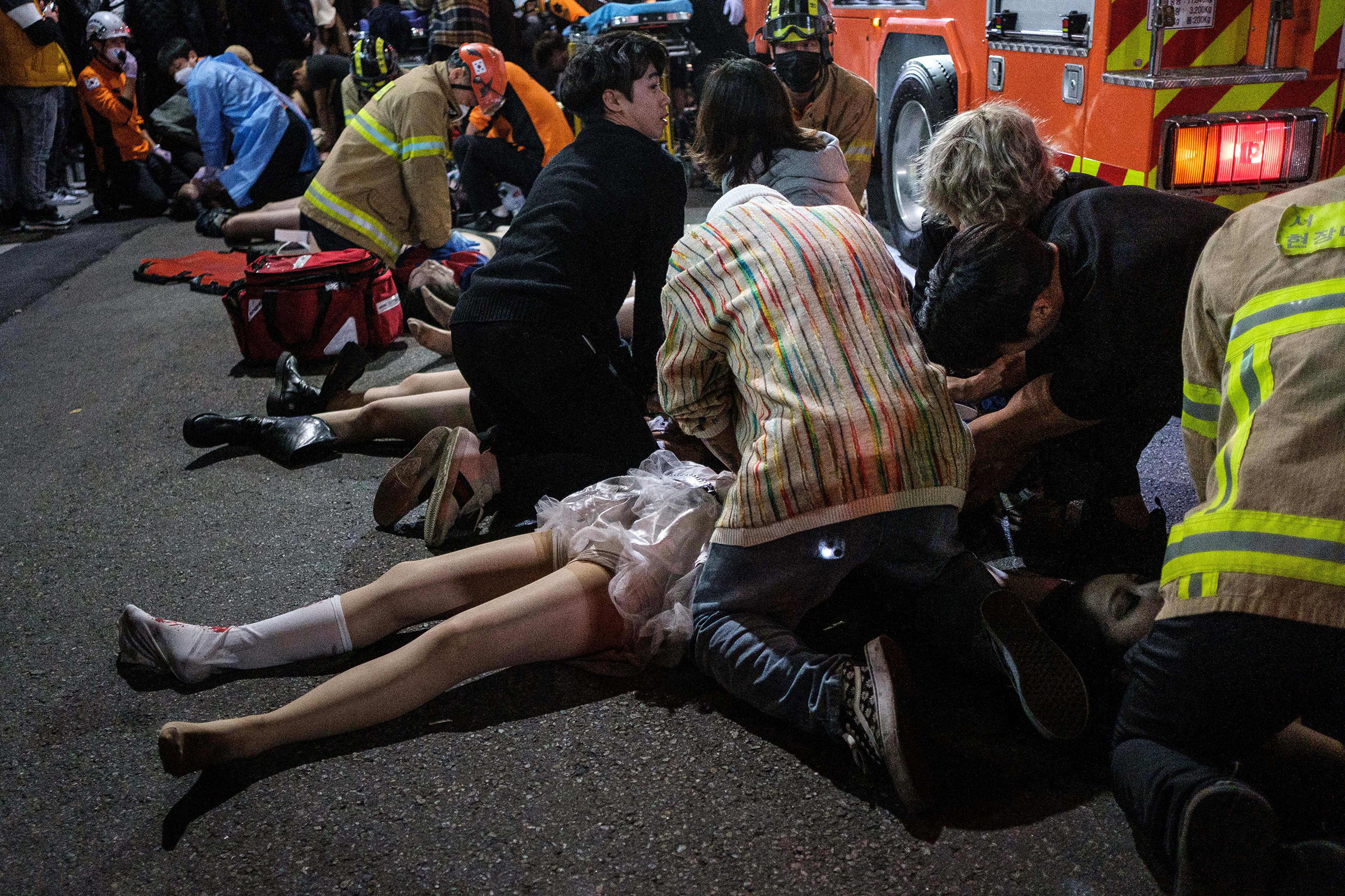 Emergency workers and others assisting people who were caught in a Halloween stampede in Itaewon, Seoul on Oct. 29. (Albert Retief—AFP/Getty Images)