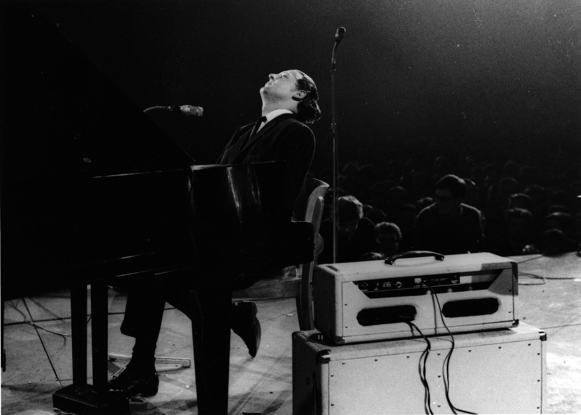 Jerry Lee Lewis performs on stage, singing into two microphones, at the Deutschlandhalle in 1963 in Berlin. (K &amp; K Ulf Kruger OHG/Redferns/Getty Images)