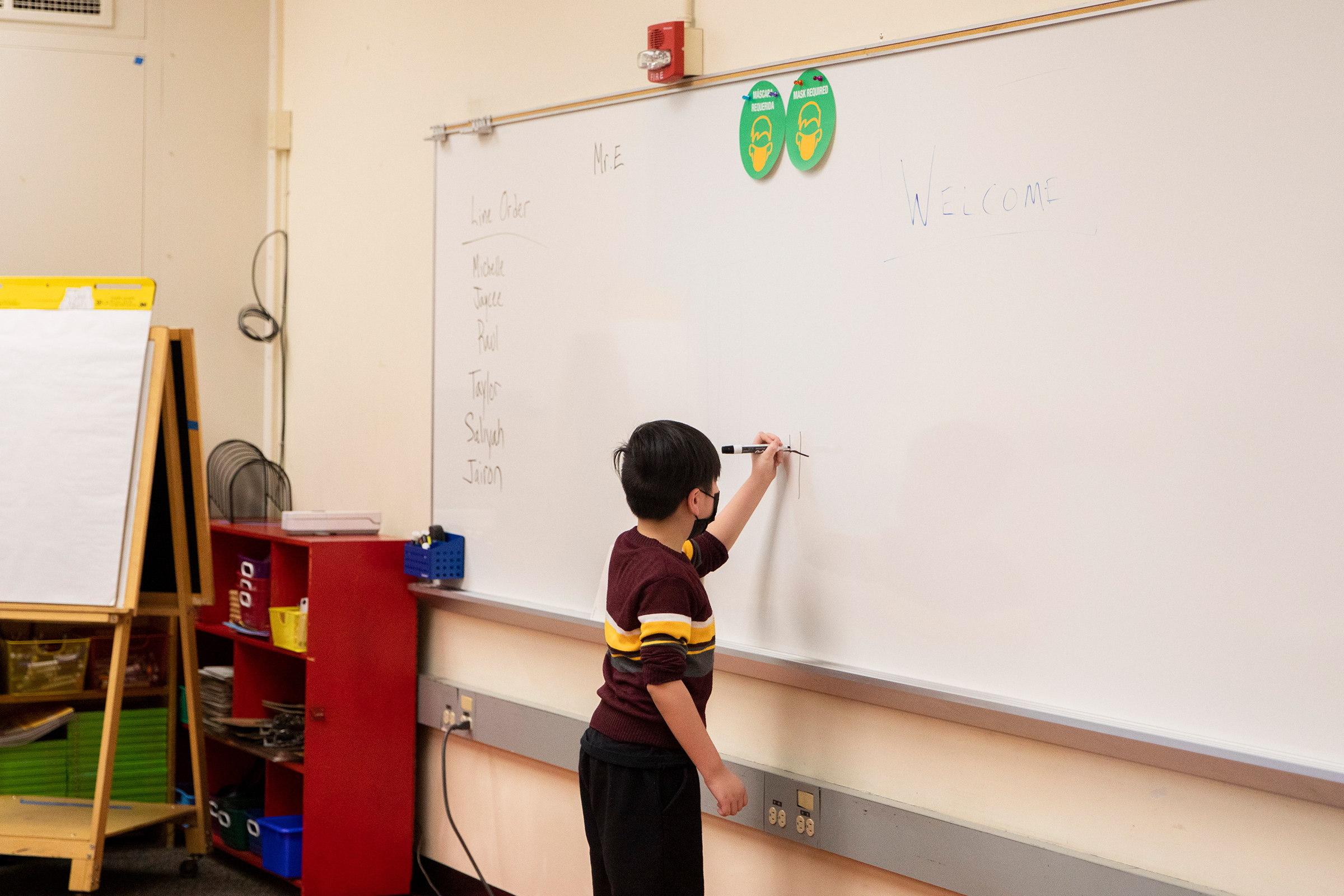 A second-grade student works on a math problem on the board at an elementary school in California. (Brianna Soukup—Portland Press Herald/Getty Images)