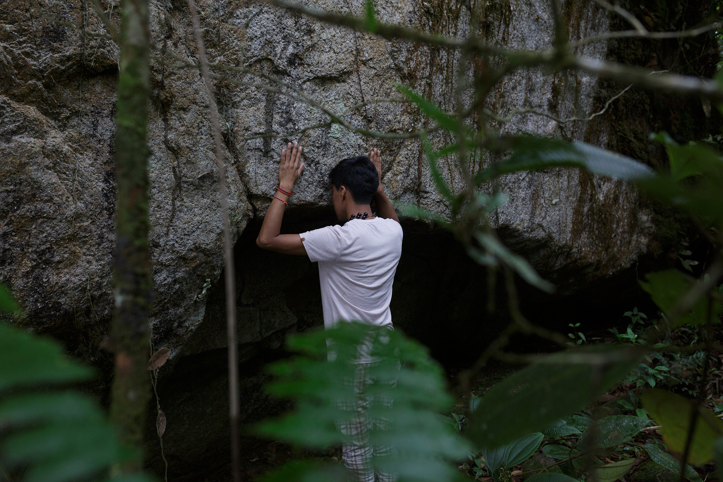 Alexis Grefa, a 26-year-old activist with the Piatúa Resiste Defense Front, near one of the river’s sacred rocks (Andrés Yépez for TIME)