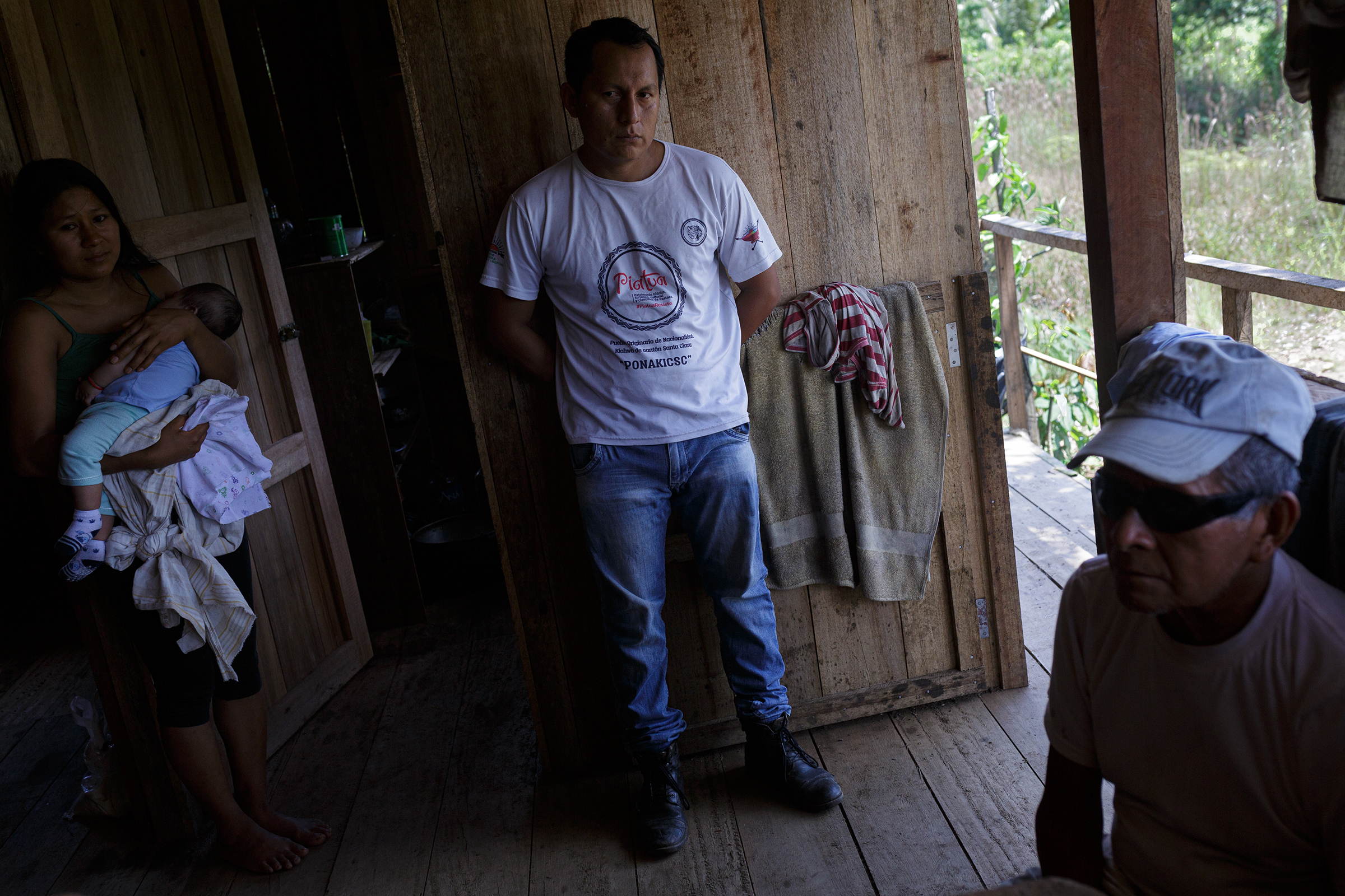 From left: María, daughter of Clemente Grefa; Darling Kaniras, a well-known activist in the community; and Clemente Grefa, pictured in Clemente’s home next to the Piatúa River. (Andrés Yépez for TIME)