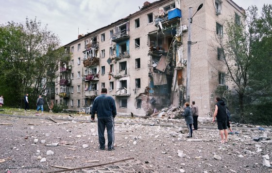 People gather to look at an apartment building damaged by two Russian rockets that hit earlier on Sept. 11, 2022, at around three o'clock in the afternoon, in Donetsk, Ukraine.