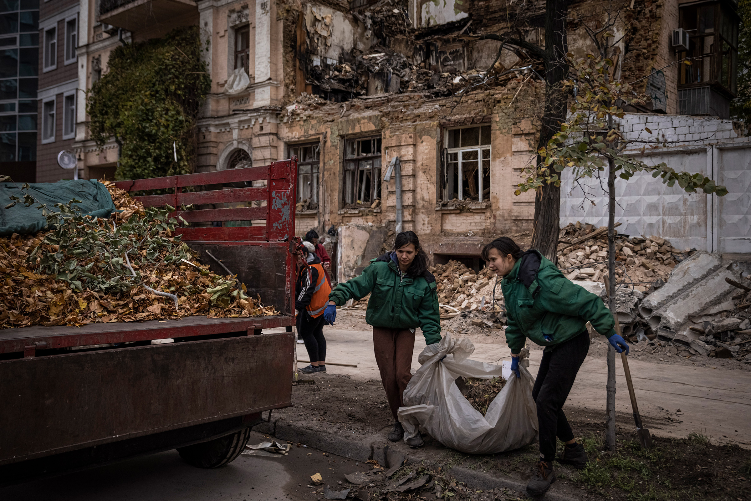 People clear blast debris and leaves outside a house where a couple was killed in a Russian drone strike two days beforehand on Oct.19 in Kyiv, Ukraine. (Ed Ram—Getty Images)