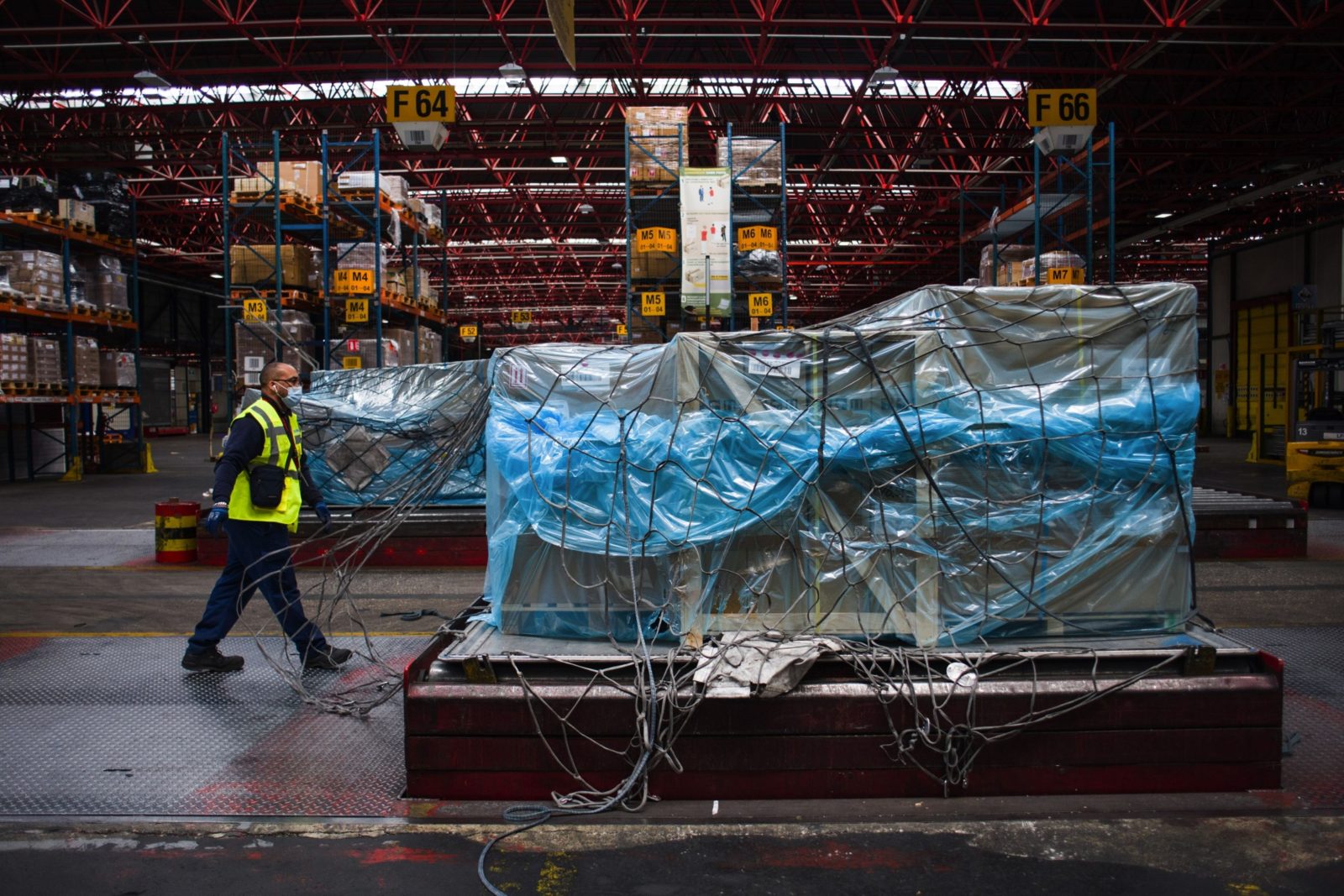 A worker passes wrapped cargo in the Air France-KLM G1XL cargo hangar at Charles de Gaulle airport in Roissy, France, on Monday, May 10, 2021. (Bloomberg&mdash;© 2021 Bloomberg Finance LP)