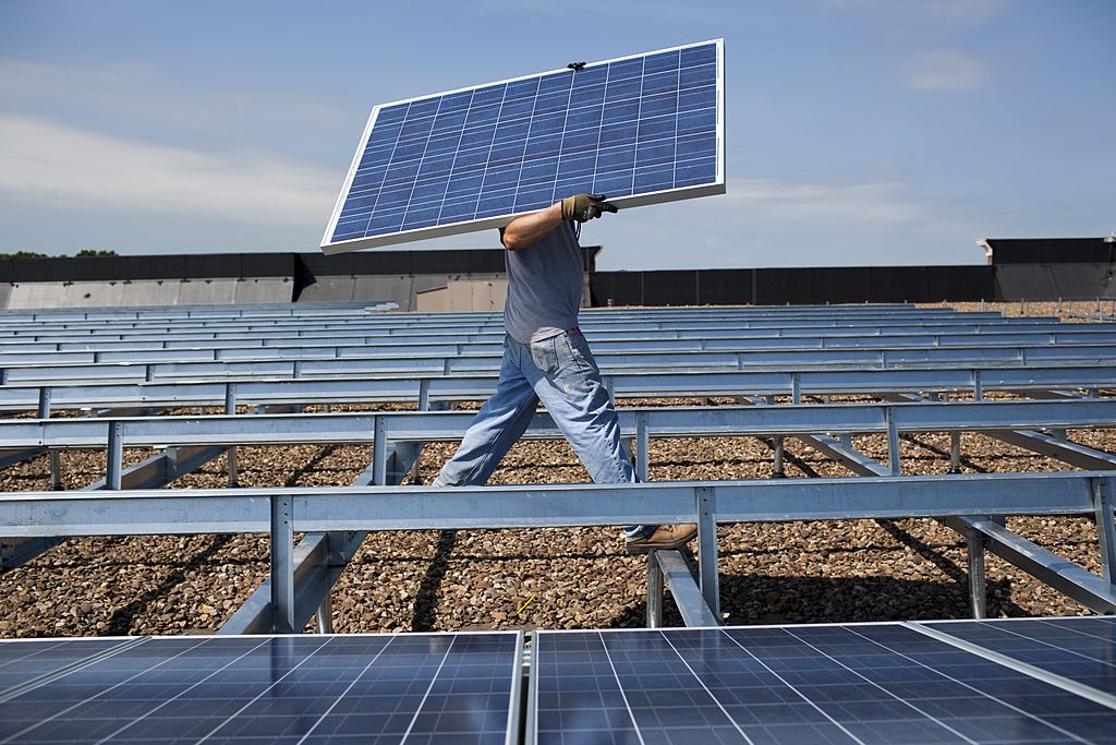 Contractors install photo voltaic modules on top of a Kohl's Department Store roof June 2, 2010 in Hamilton Township, New Jersey. (Robert Nickelsberg—Getty Images)