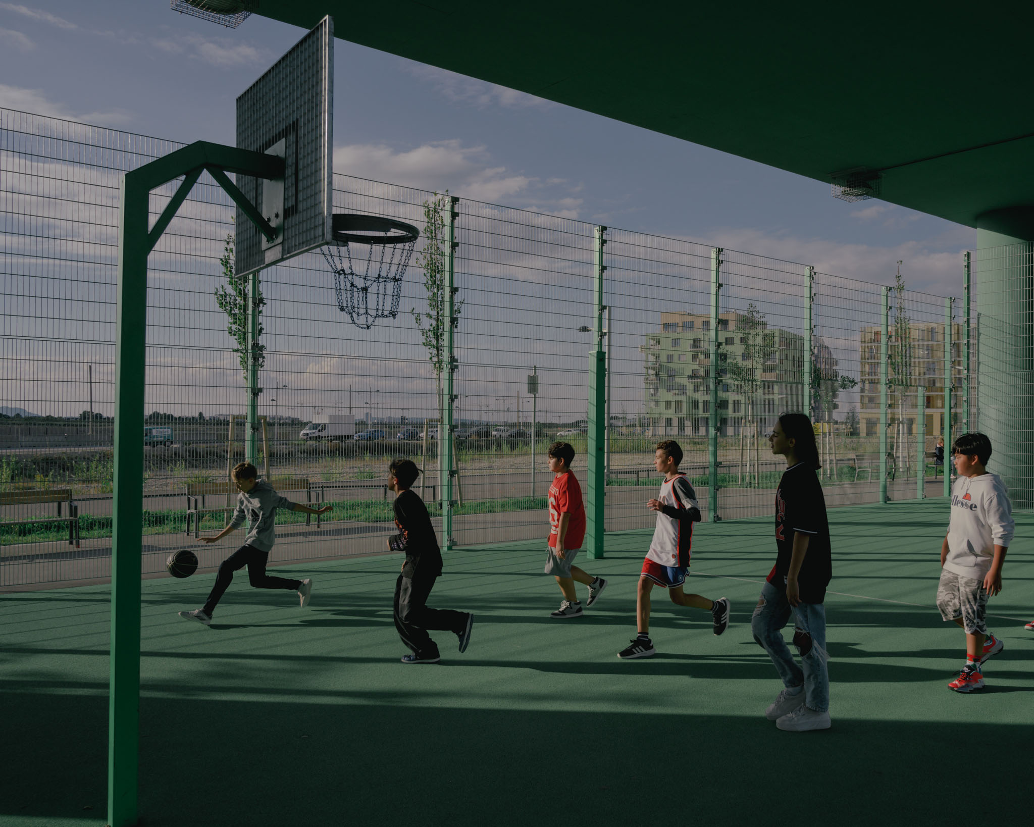 Bölgede asma köprünün altına basketbol ve futbol sahaları, tırmanma tesisleri ve oyun alanları yapıldı. "Seebogen'im" Viyana, Avusturya mahalle.  Çocuklar 26 Eylül 2022'de birlikte oynarken görülüyor. (TIME için Ingmar Björn Nolting)