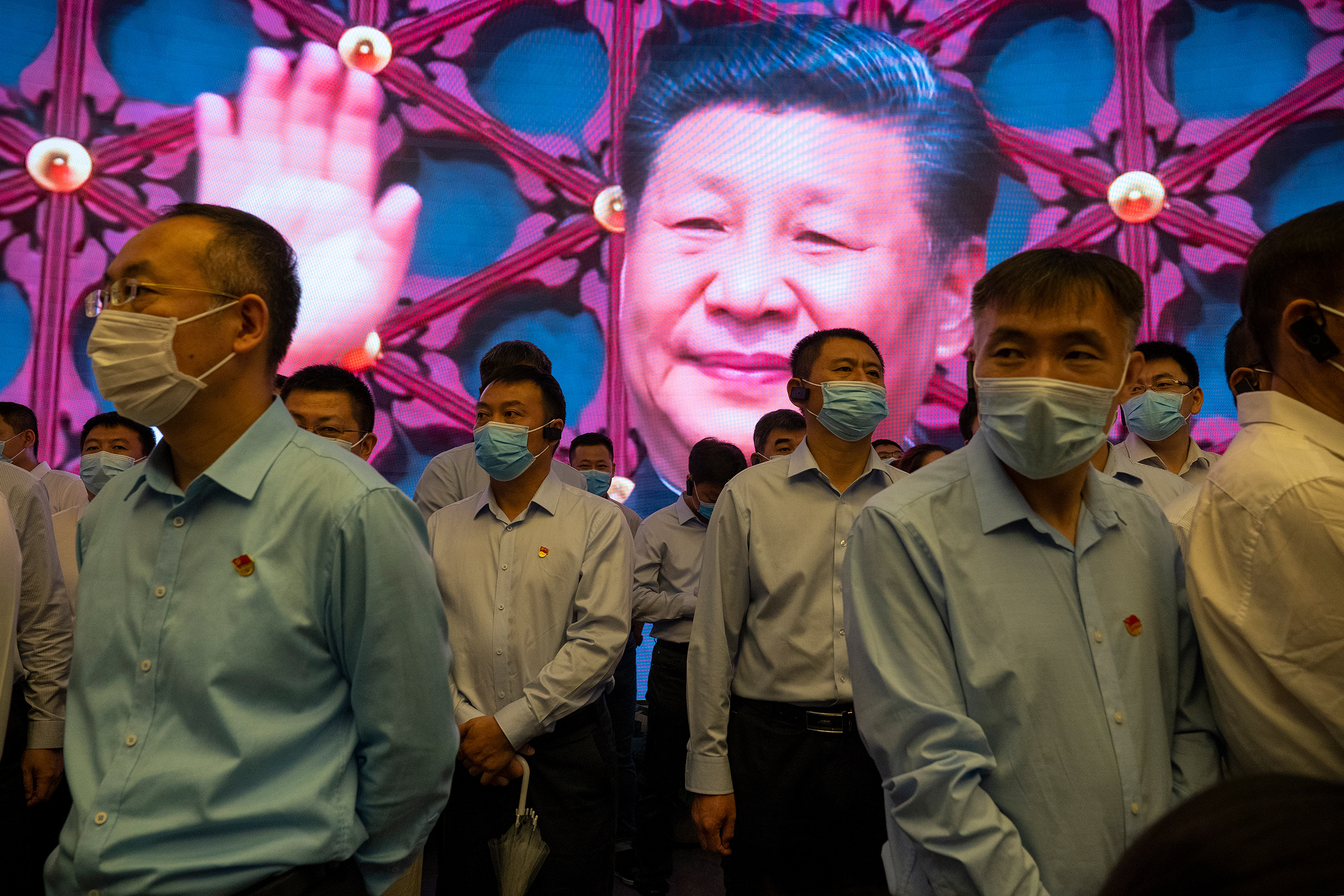 Visitors stand inside the Memorial of the FirstNational Congress of the Communist Party of China, as Xi is seen on the screen in the back, on June 17, 2021 in Shanghai, China. (Andrea Verdelli—Getty Images)