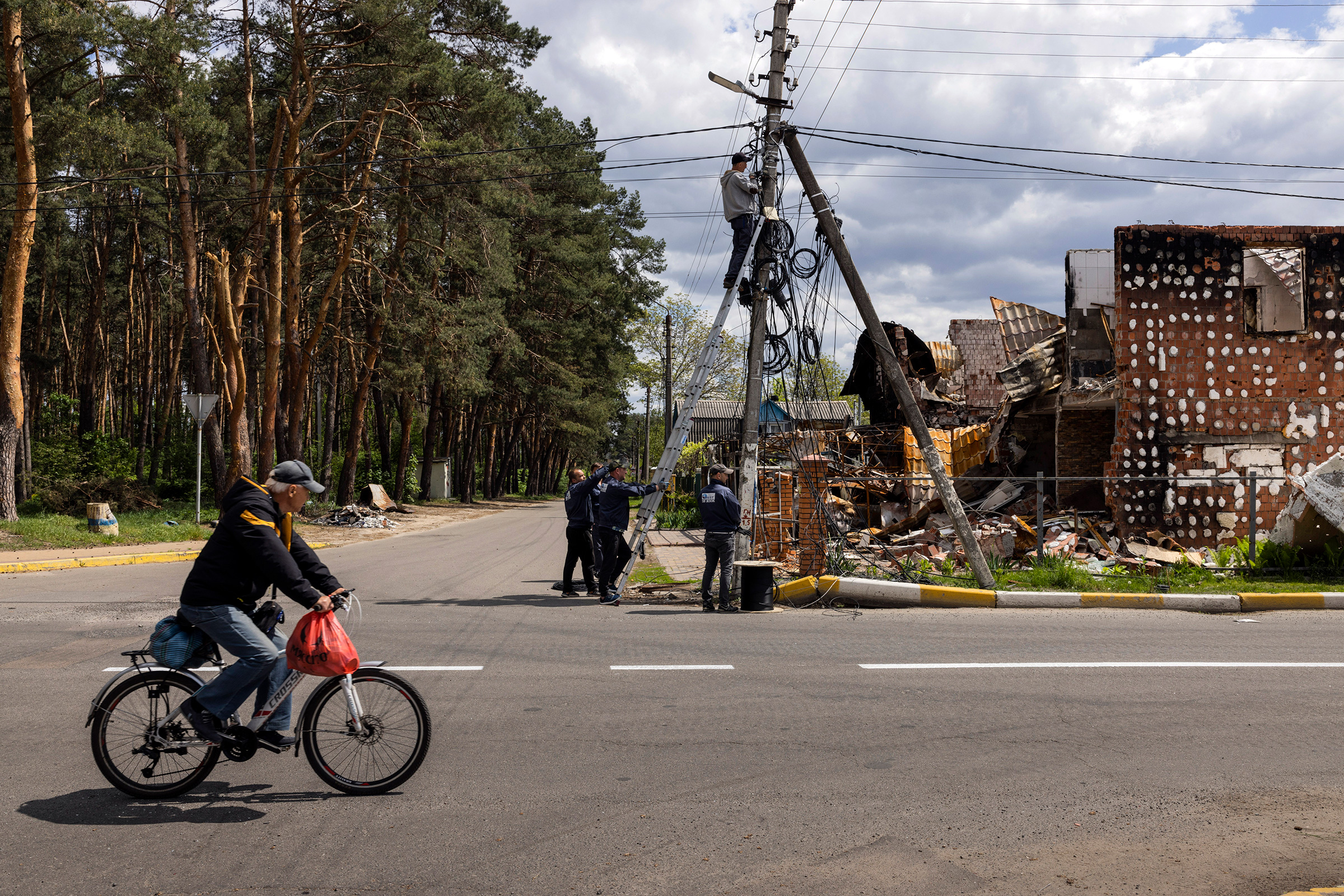 Men work to restore internet access to a neighborhood in Irpin, a suburb of Kyiv, Ukraine, on May 16. (Ivor Prickett—The New York Times/Redux)