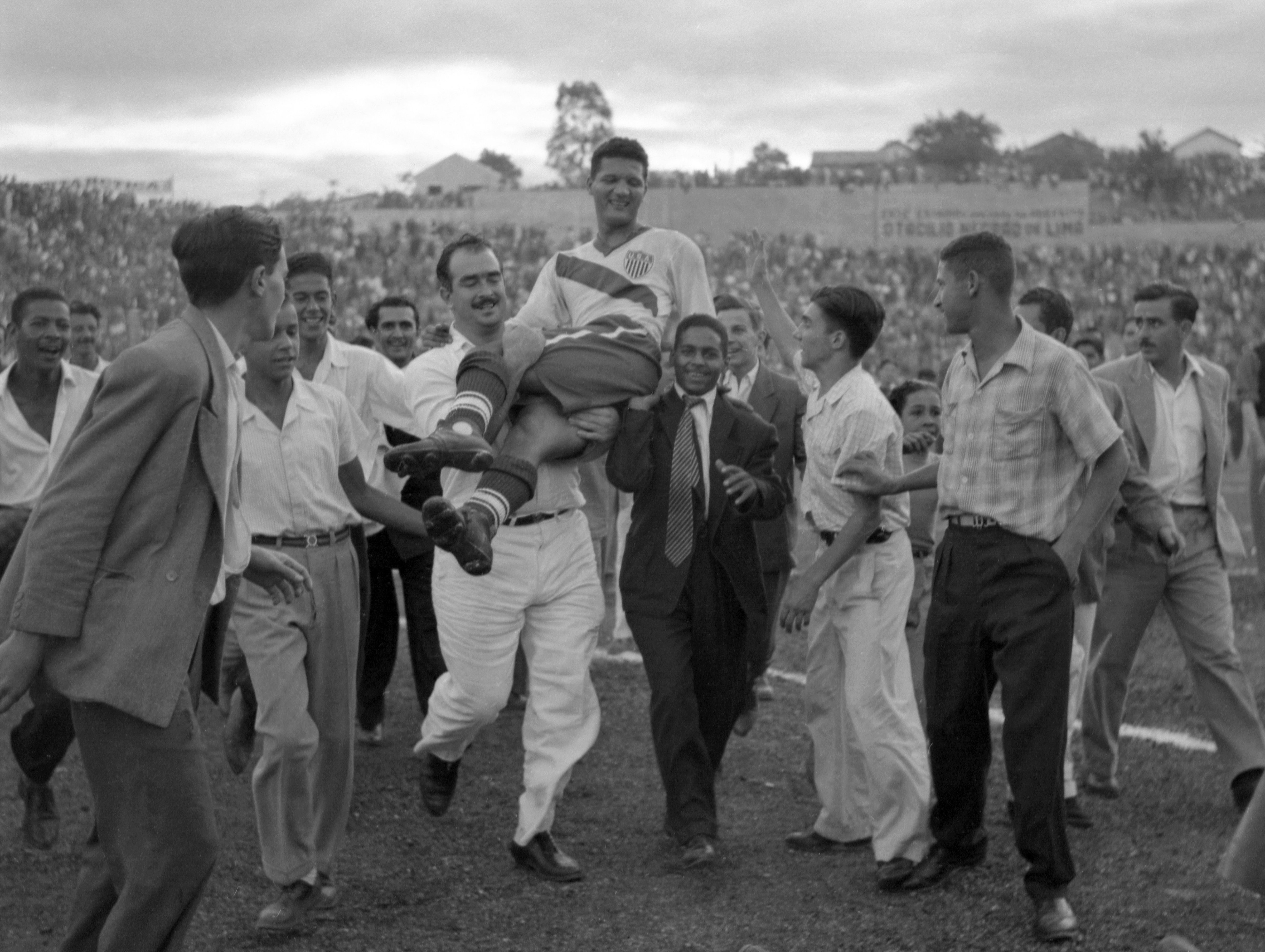 ABD'li forvet Joe Gaetjens, 28 Haziran 1950'de Brezilya'nın Belo Horizonte kentinde düzenlenen Dünya Kupası futbol maçında ABD Takımı İngiltere'yi 1-0 yendikten sonra tezahürat yapan taraftarlar tarafından taşınıyor. (AP)