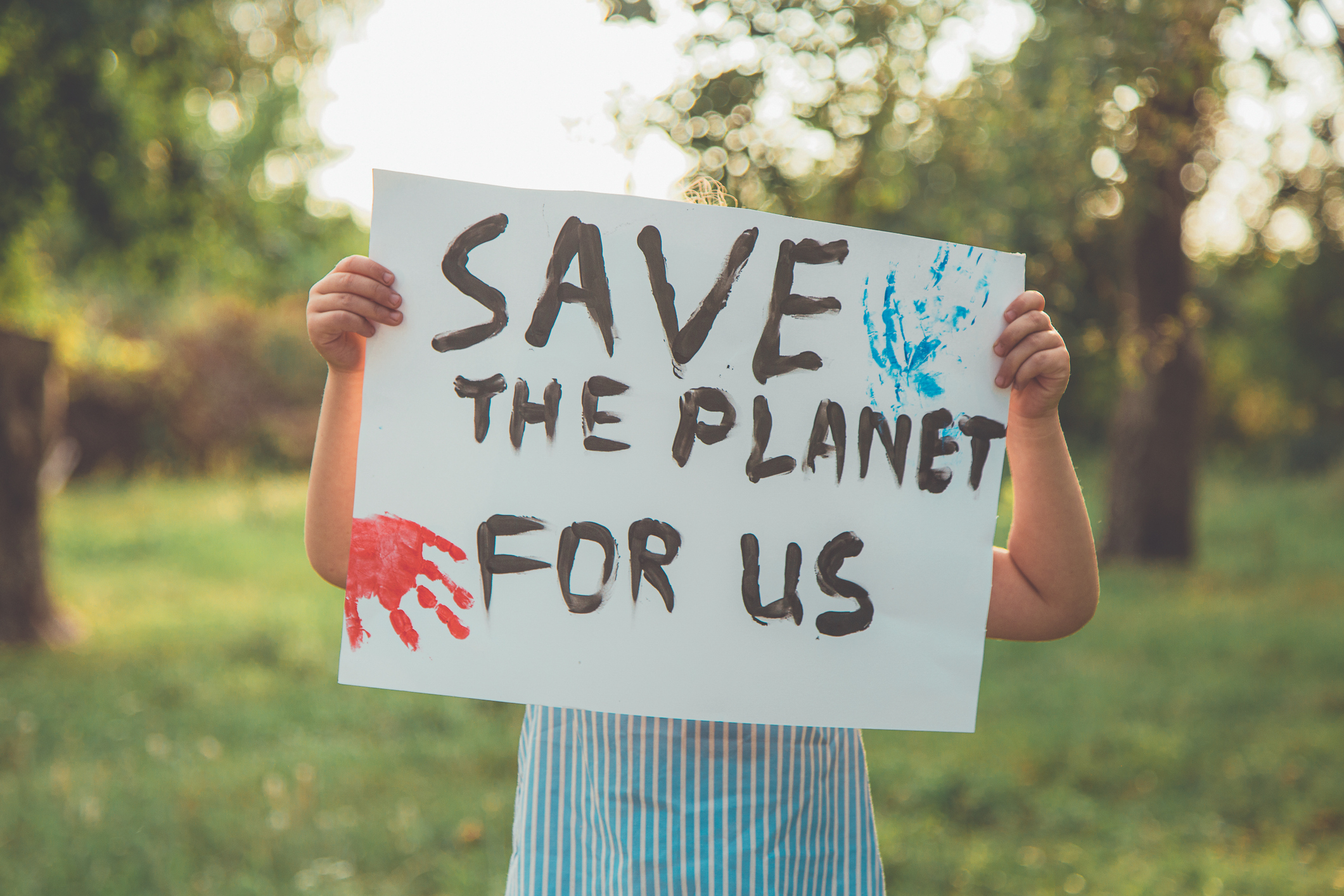 Kid with posters protecting the planet. Protest