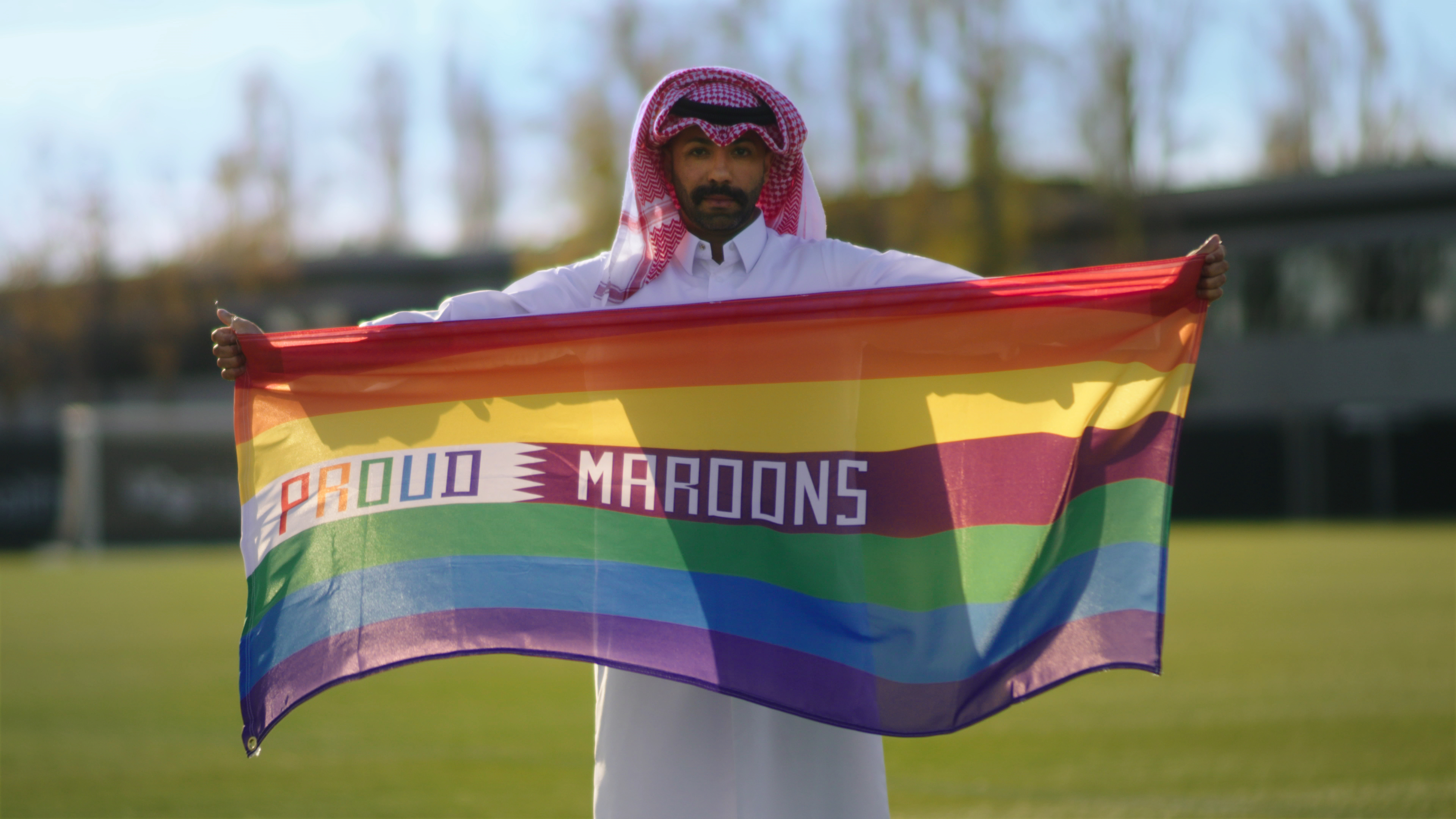 Dr. Naser Mohamed holds a "Proud Maroons" rainbow flag. (Alwan Foundation)