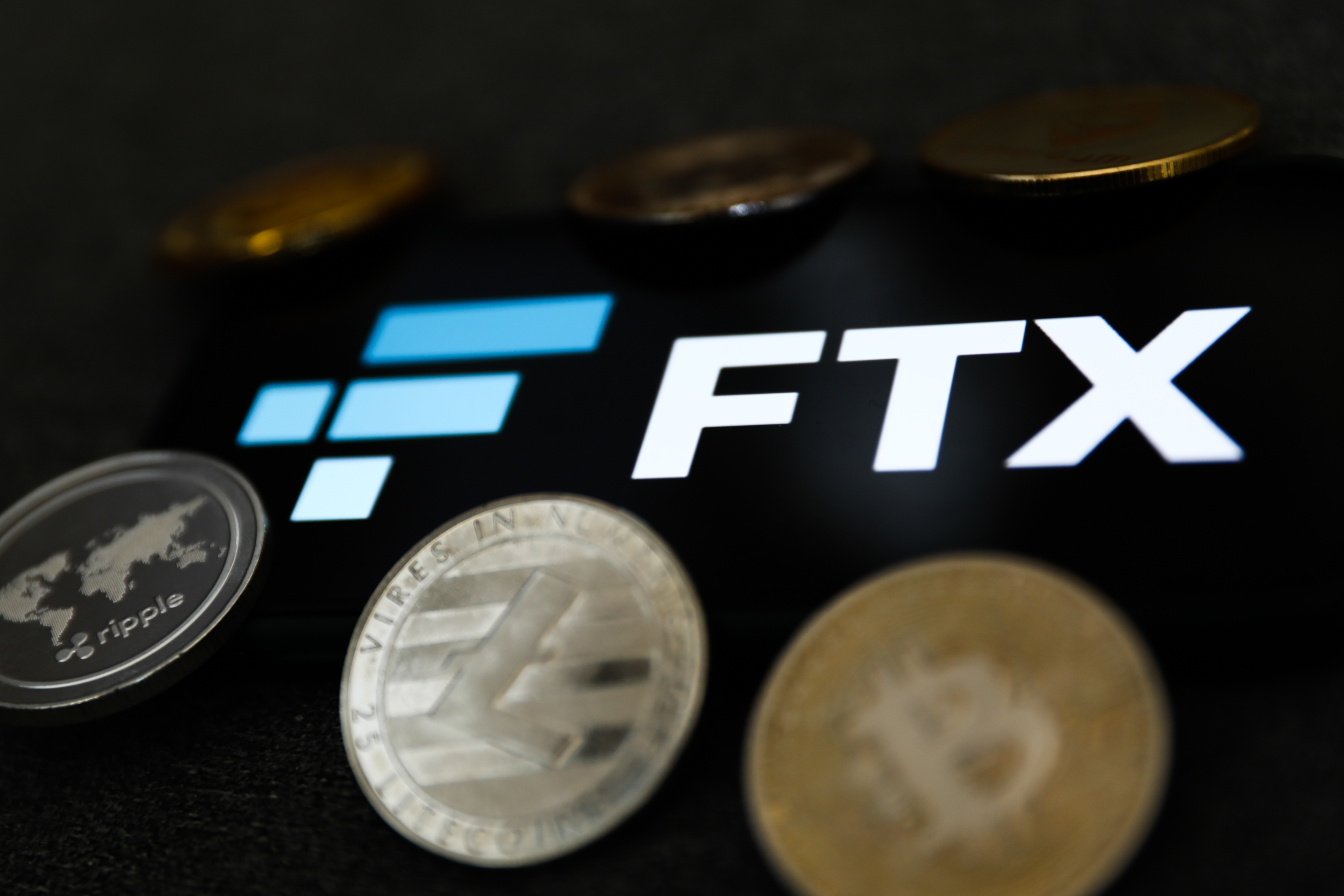 FTX logo displayed on a phone screen and representation of cryptocurrency are seen in this illustration photo taken in Krakow, Poland on February 16, 2022. (Jakub Porzycki–NurPhoto via Getty Images)