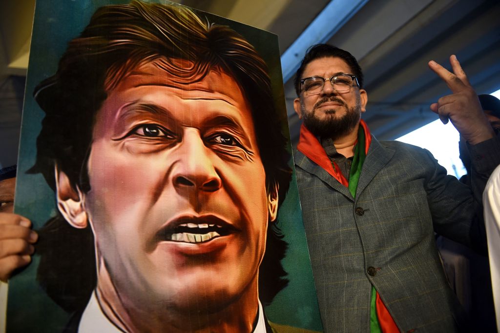 A supporter of Pakistan's former prime minister Imran Khan, gestures while holding Khan's portrait during a protest against the assassination attempt on him, in Karachi on November 6, 2022. - Khan left hospital on November 6, a senior aide said, three days after being shot in the legs in a failed assassination attempt. (Rizwan TABASSUM- AFP)