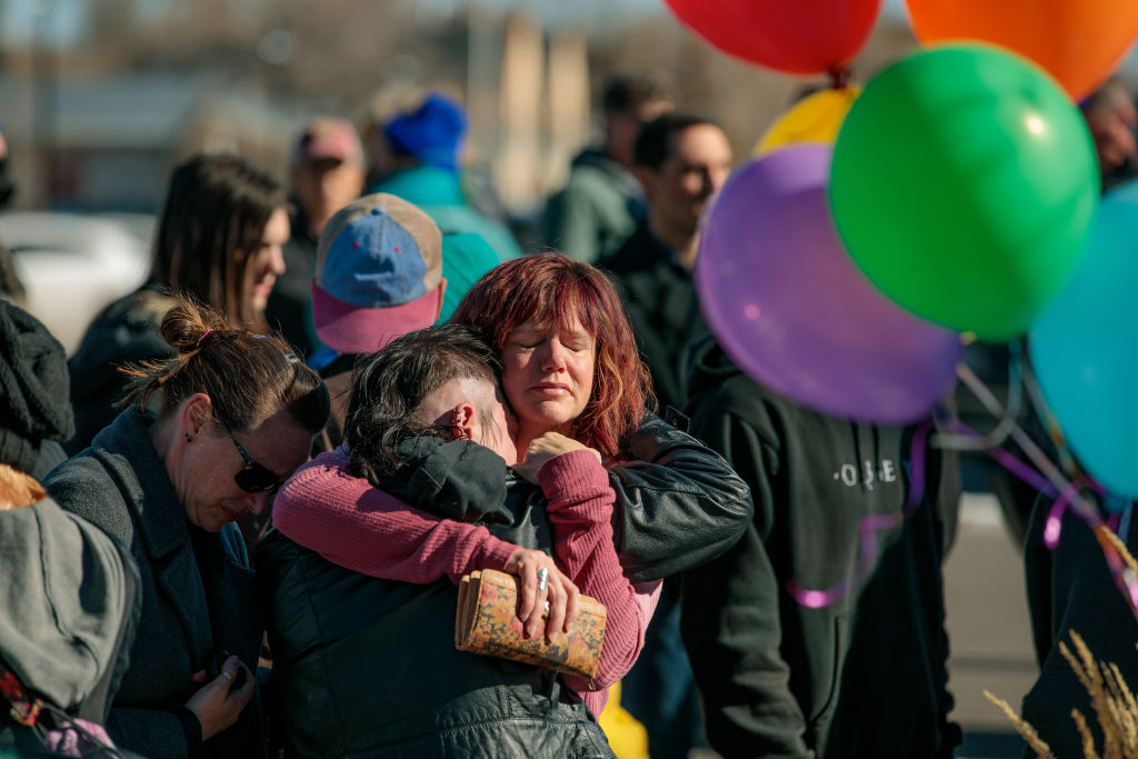 Liz Guerra, right, Eli King (back to camera) and Tiffany Blackwell embrace in the overflow crowd outside a vigil related to the Club Q shooting at All Souls Unitarian Church on Sunday November 20, 2022 in Colorado Springs, Colo. (Matthew Staver—For the Washington Post)