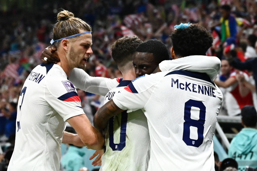 Forward Timothy Weah embraces teammates after scoring the U.S.'s first goal during the Qatar 2022 World Cup in the match against Wales at the Ahmad Bin Ali Stadium, Nov. 21, 2022. (Jewel Samad—AFP/Getty Images)
