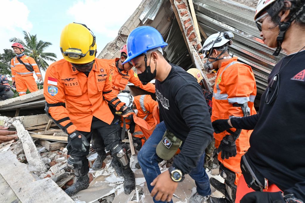 Rescue workers carry the body of a victim in Cianjur on Nov. 22, 2022, following a 5.6-magnitude earthquake that killed at least 162 people, with hundreds injured and others missing. (Adek Berry—AFP via Getty Images)