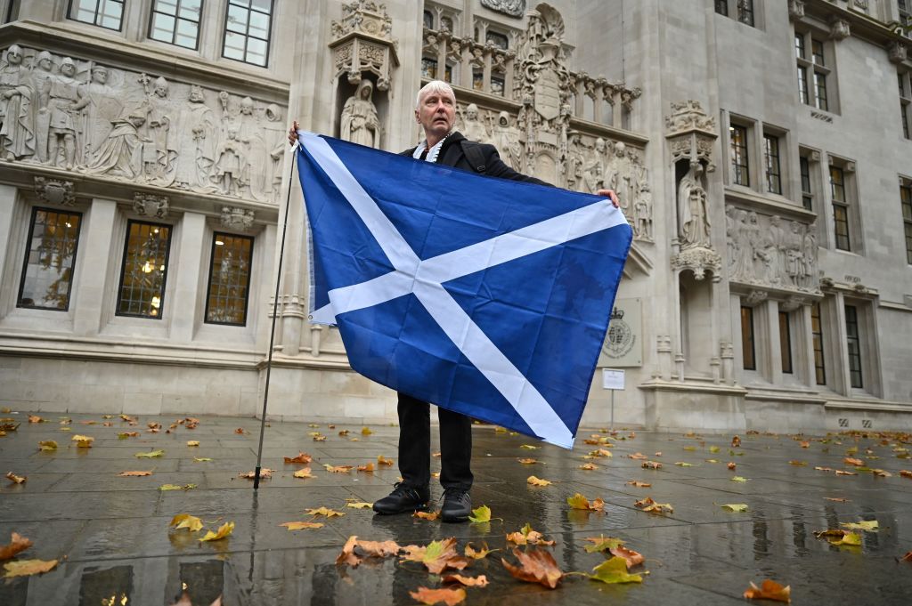 A Scottish independence supporter poses with the flag of Scotland outside the Supreme Court in London on Nov. 23, 2022, after the court blocked a new vote on independence. (Justin Tallis—AFP via Getty Images)