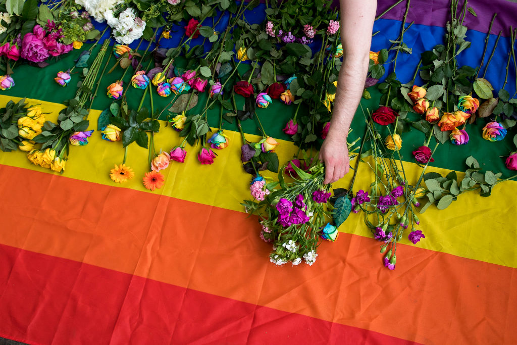 Demonstrators lay roses on a rainbow flag as they protest outside the Russian Embassy on June 2, 2017 in London over a crackdown on gay men in Chechnya. (Justin Tallis—AFP via Getty Images)