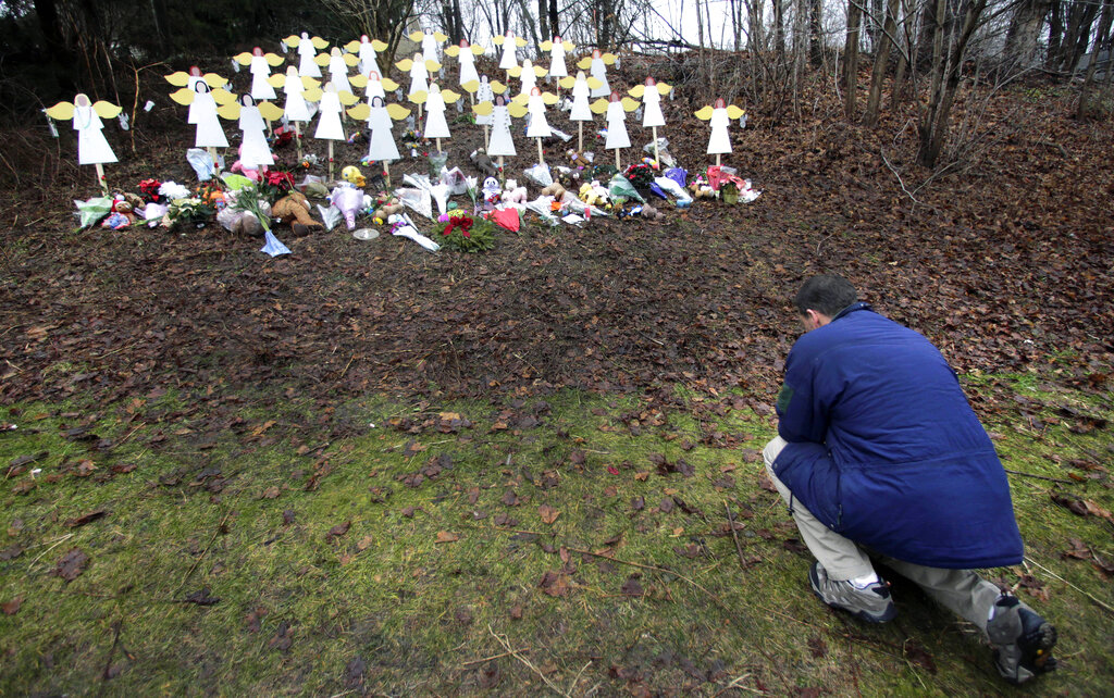 In this file photo, Robert Soltis, of Newtown, Conn., pauses after making the sign of the cross at a memorial to Sandy Hook Elementary School shooting victims in Newtown, CT, on Dec. 18, 2012. (Charles Krupa—AP)