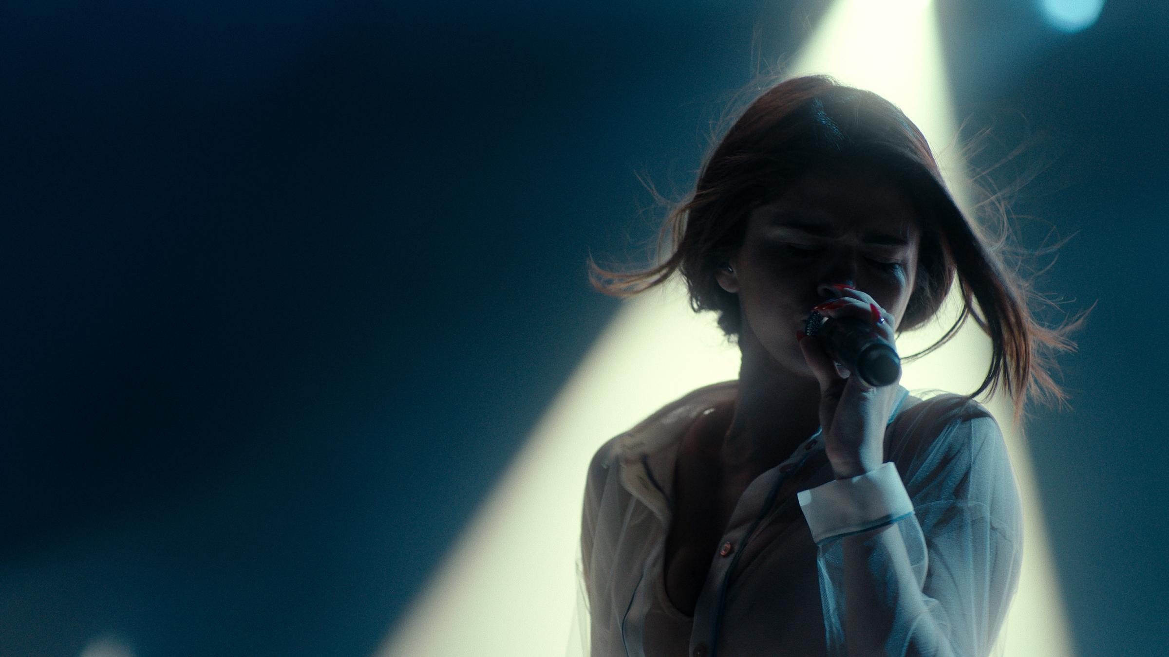 Selena Gomez singing into a microphone