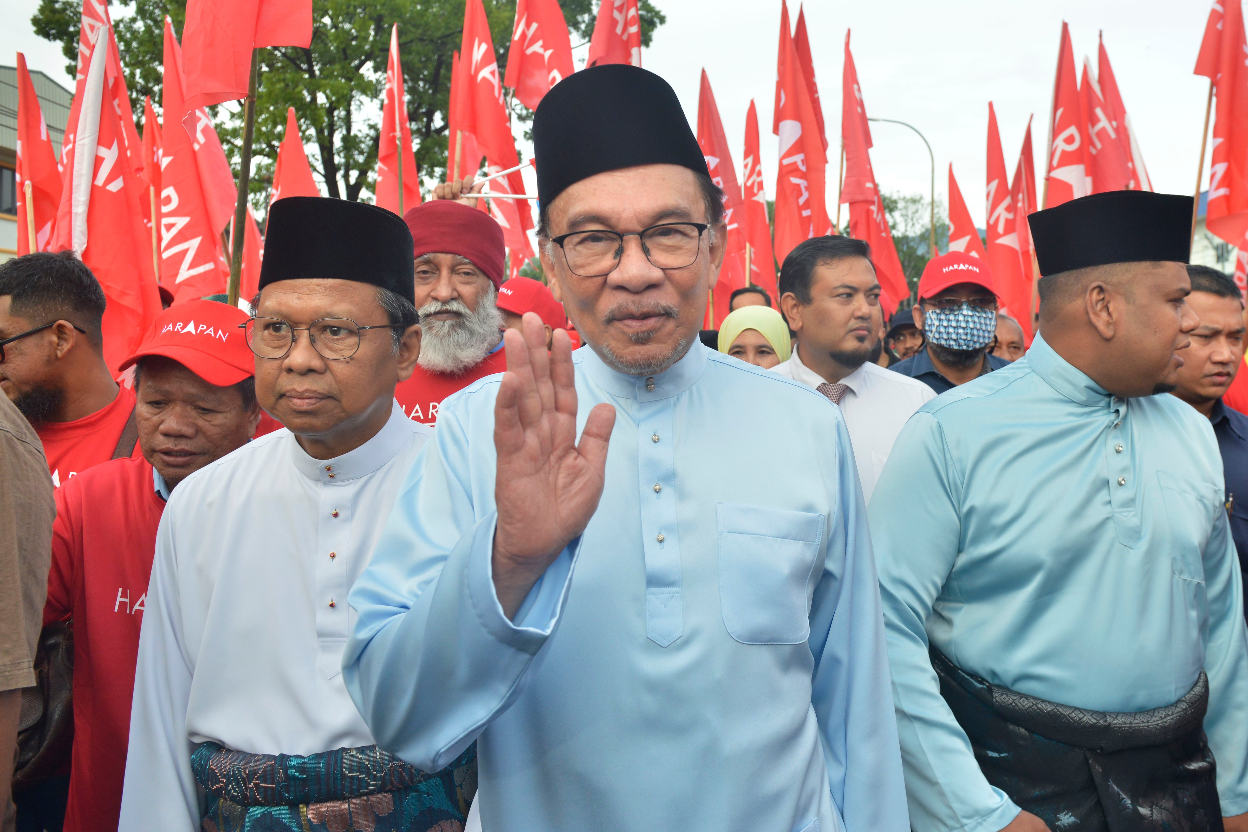 Malaysian opposition leader Anwar Ibrahim waves to his supporters as he arrives at a nomination center for the upcoming general election in Tambun, Malaysia, Saturday, Nov. 5, 2022. Malaysia's king on Thursday, Nov. 24, 2022, named Anwar as the country's prime minister, ending days of uncertainties after divisive general elections produced a hung Parliament. (John Shen Lee–AP)