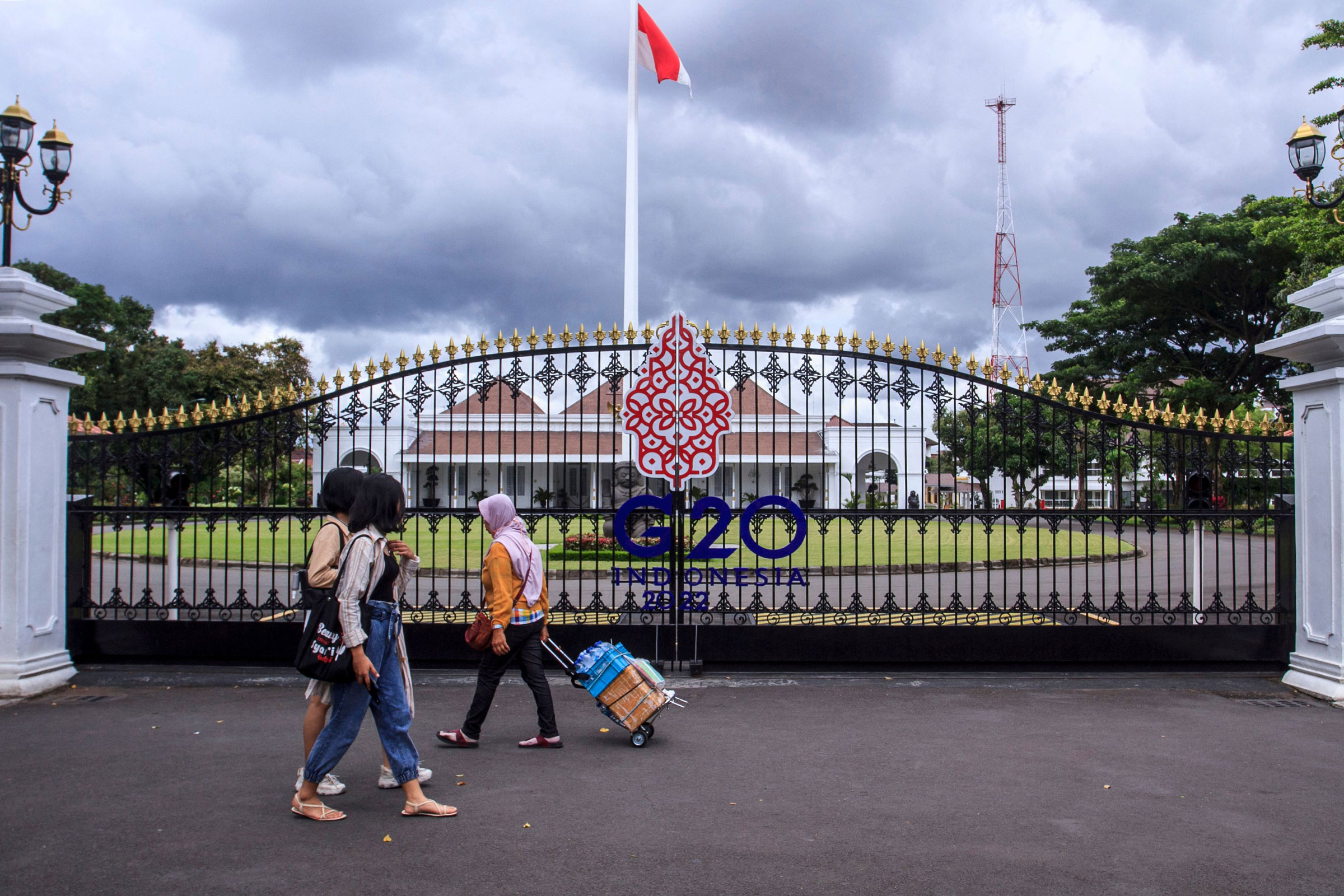 People walk by the main gate of the Kraton, also known as the Palace of Yogyakarta, in Indonesia on Oct. 30, 2022, which has been prepared to welcome the upcoming G20 summit to be held in Bali on Nov. 14-16, 2022. (Devi Rahman—AFP/Getty Images)