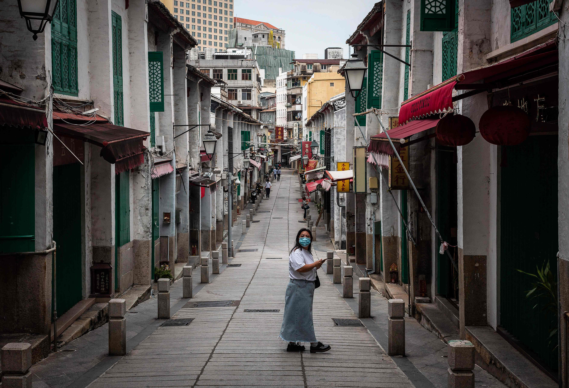 A pedestrian looks on as she walks in a street in the historical centre in Macau on Oct. 10. (Eduardo Leal—AFP/Getty Images)
