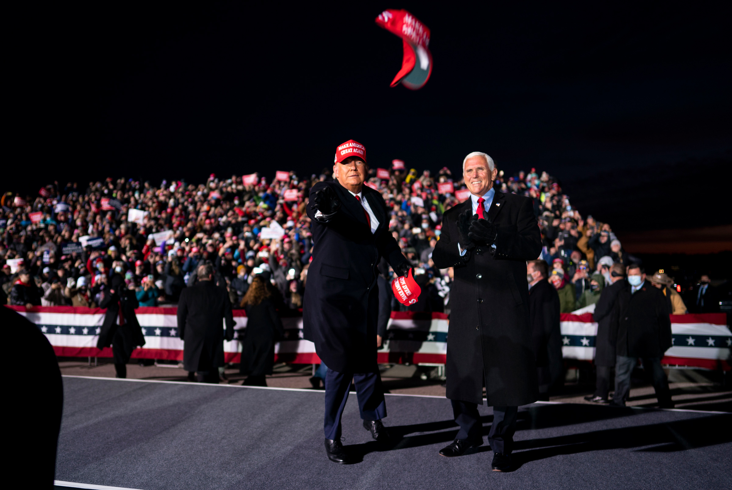 President Donald Trump tosses campaign hats to the audience during a campaign rally with Vice President Mike Pence at  Cherry Capital Airport in Traverse City, Mich., on Nov, 2, 2020. (Doug Mills—The New York Times/Redux)