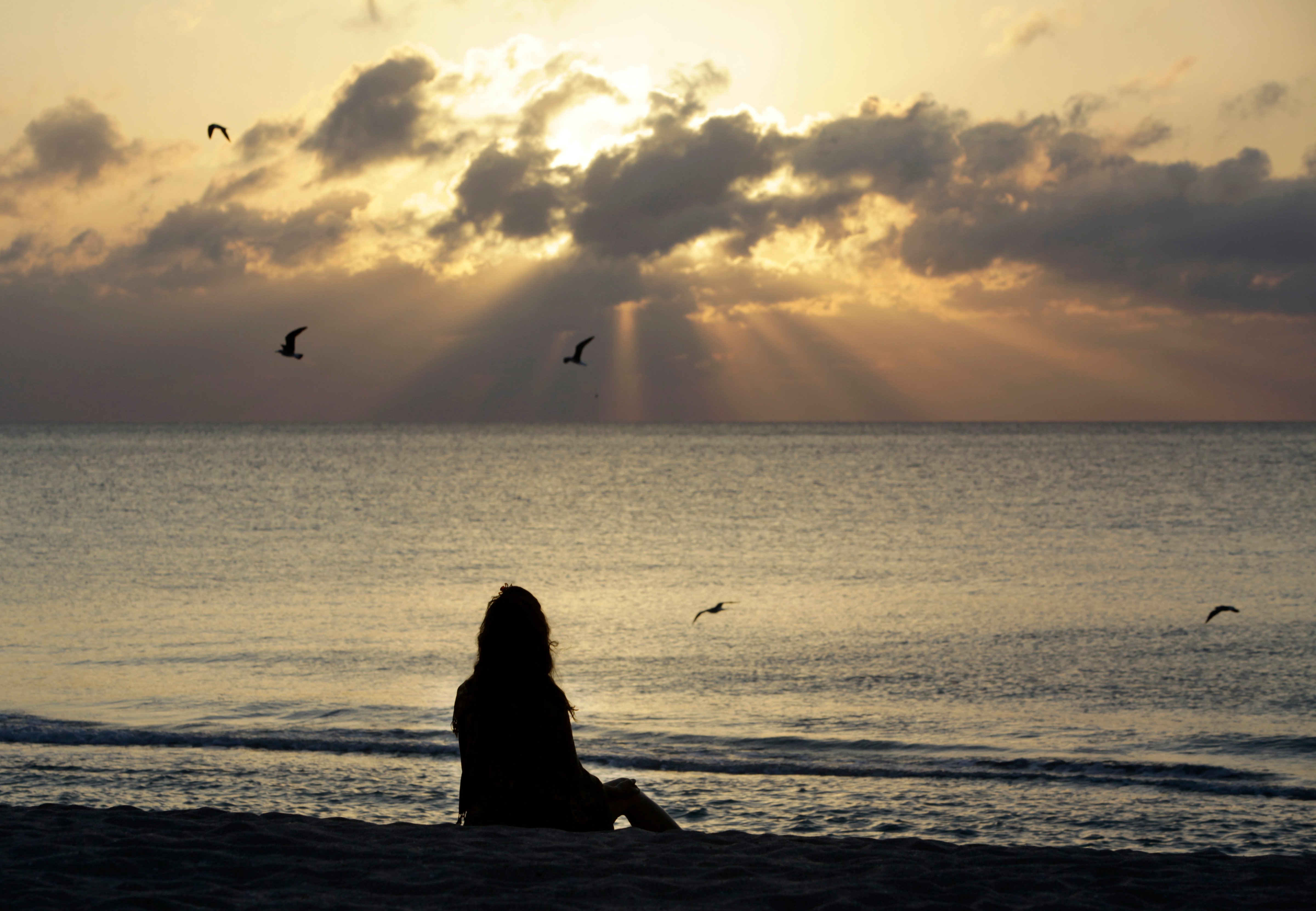 A woman meditates on the beach in Miami Beach, Fla. (Lynne Sladky—AP Photo)