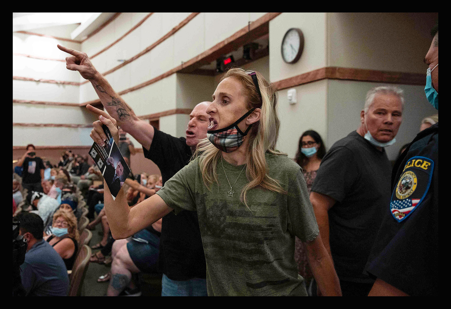Protesters against a COVID-19 mandate gesture as they are escorted out of the Clark County School Board meeting at the Clark County Government Center, in Las Vegas, on Aug. 12, 2021. (Bizuayehu Tesfaye—Las Vegas Review-Journal/AP)