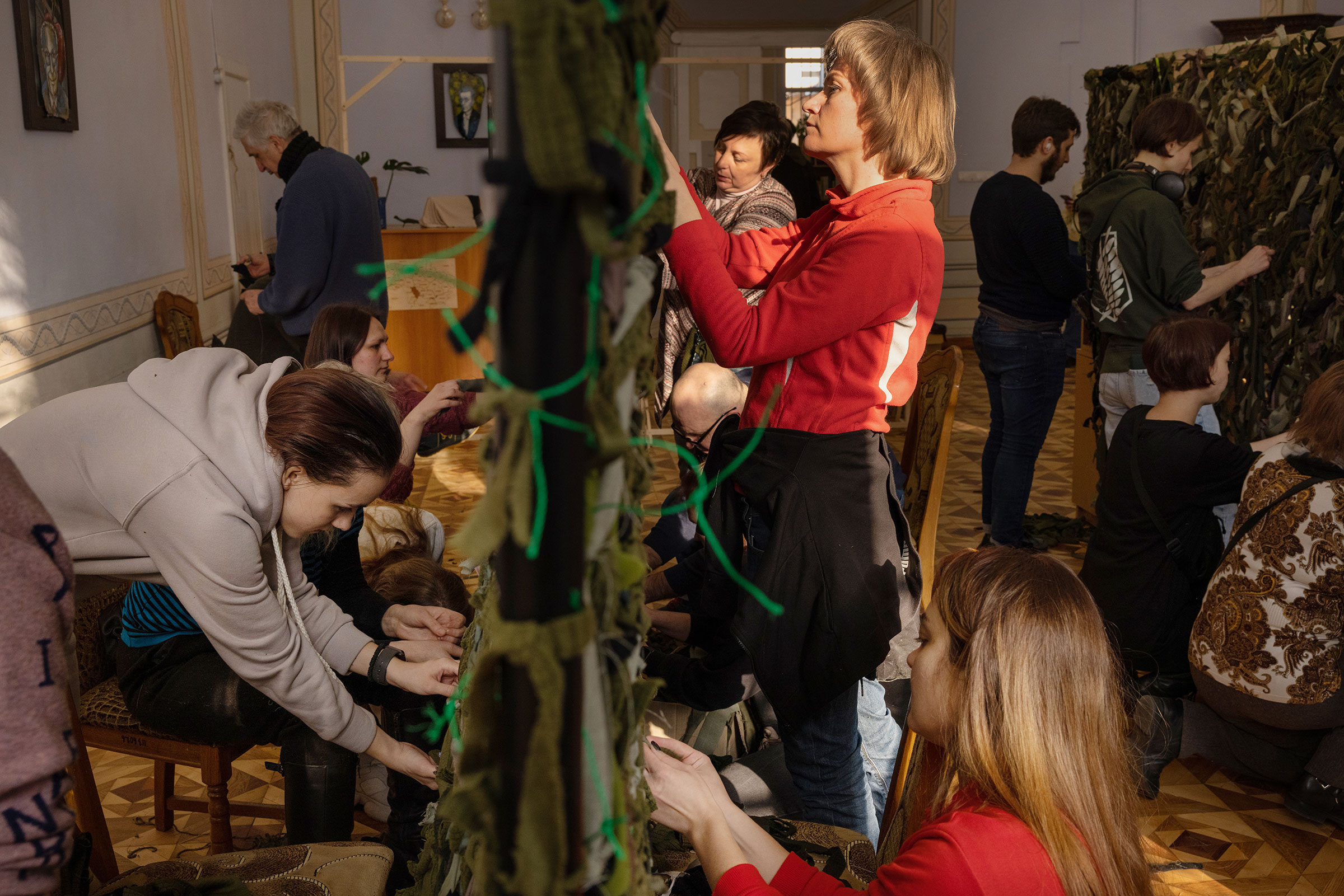 Volunteers at a library in central Lviv, Ukraine, weave camouflage nets to send to the soldiers on the front lines on March 7. (Natalie Keyssar for TIME)