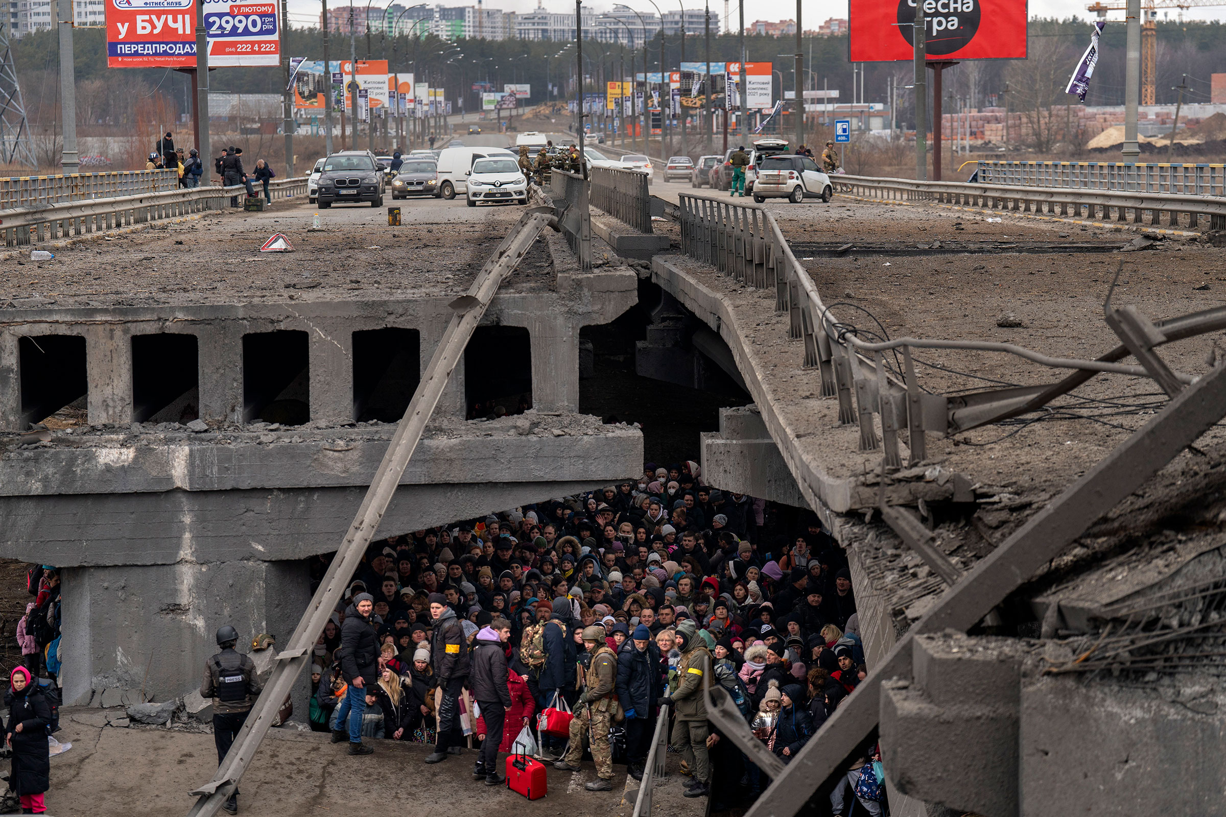 Ukrainians crowd under a destroyed bridge as they try to flee crossing the Irpin river in the outskirts of Kyiv, Ukraine, on March 5.